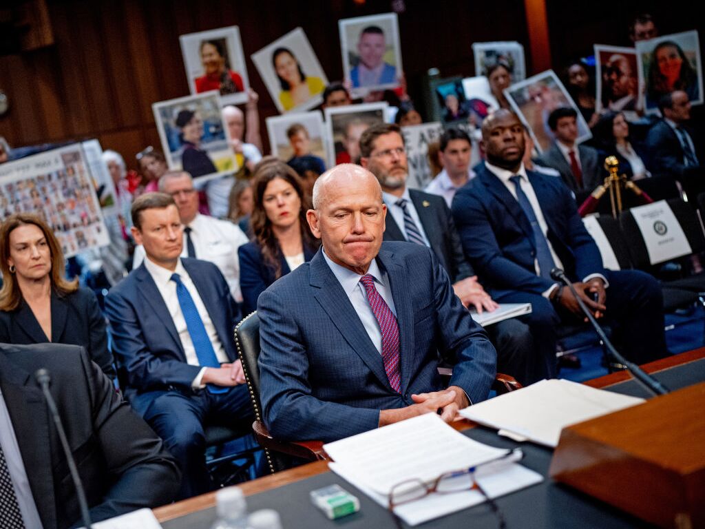 caption: Boeing CEO Dave Calhoun testified before a Senate subcommittee last month, while family members of those killed in crashes of two Boeing 737 Max 8 jets in 2018 and 2019 held photographs of their loved ones.<br>