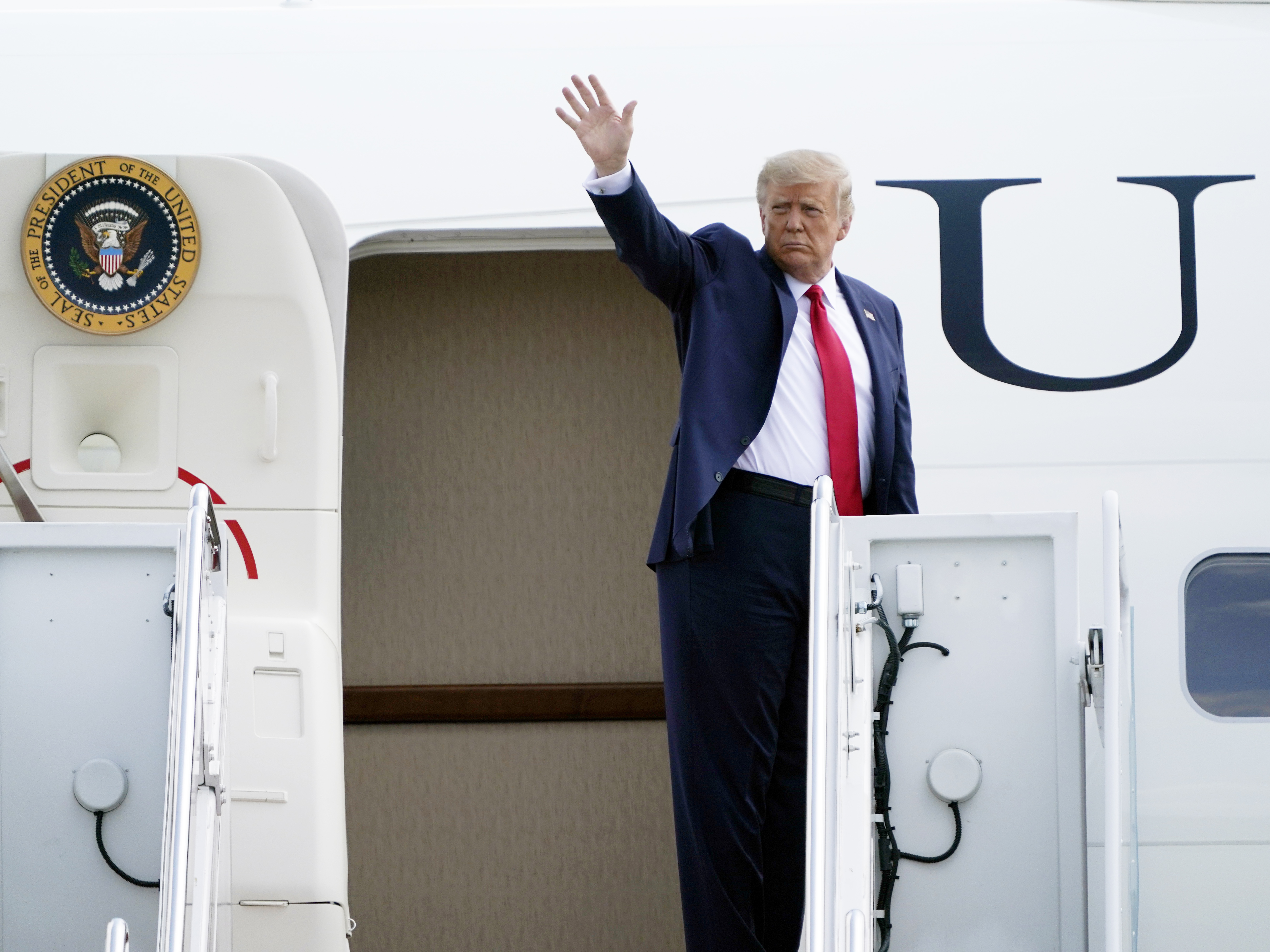 caption: President Trump boards Air Force One on Tuesday at Andrews Air Force Base in Maryland.