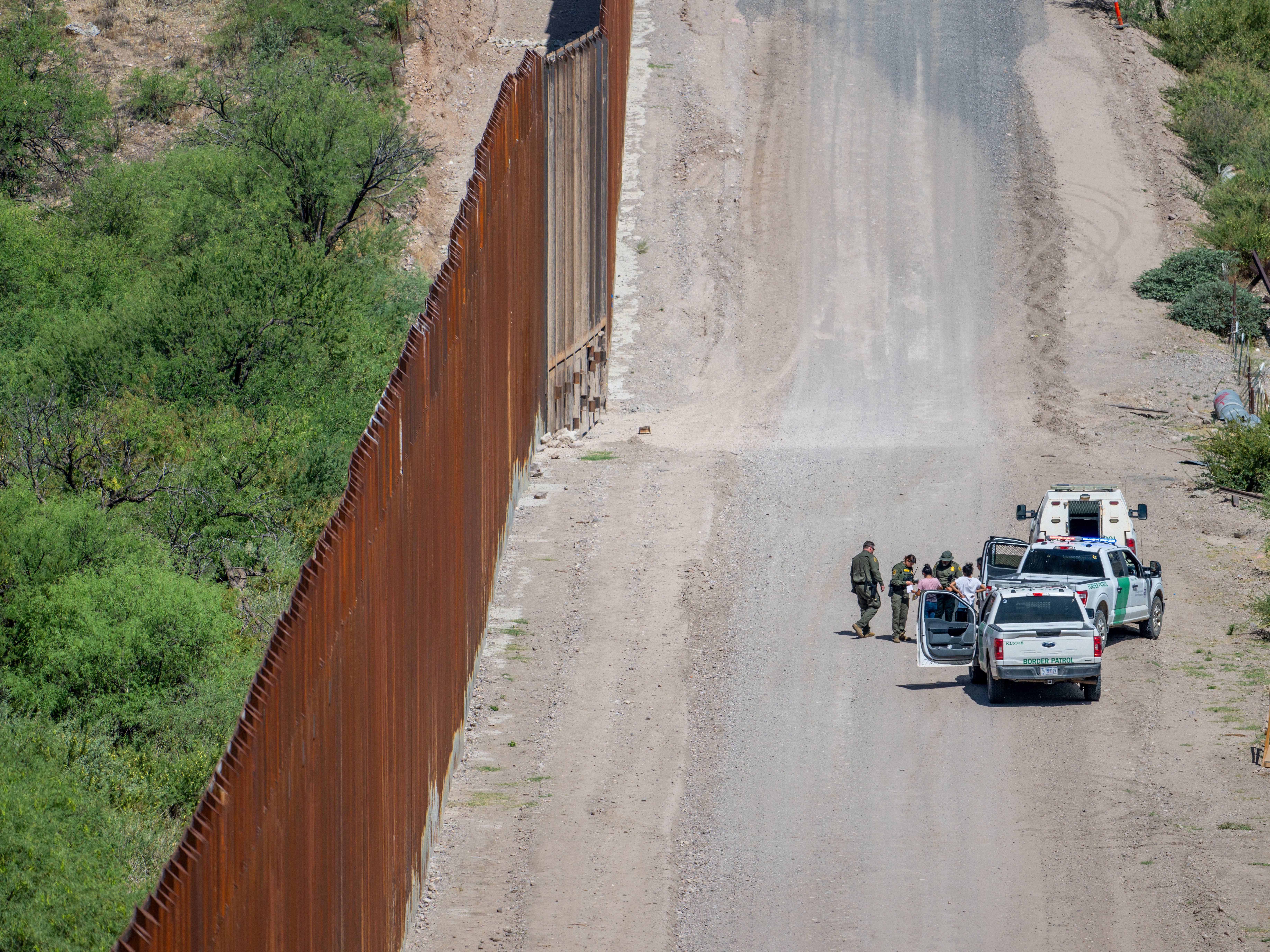 caption: A group of migrants are apprehended by U.S. Customs and Border protection officers after crossing over into the U.S. on June 26, 2024 in Ruby, Arizona.