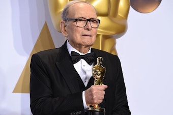 caption: Composer Ennio Morricone, posing with his Oscar for <em>The Hateful Eight </em>in 2016. He died Monday at age 91 in Rome.