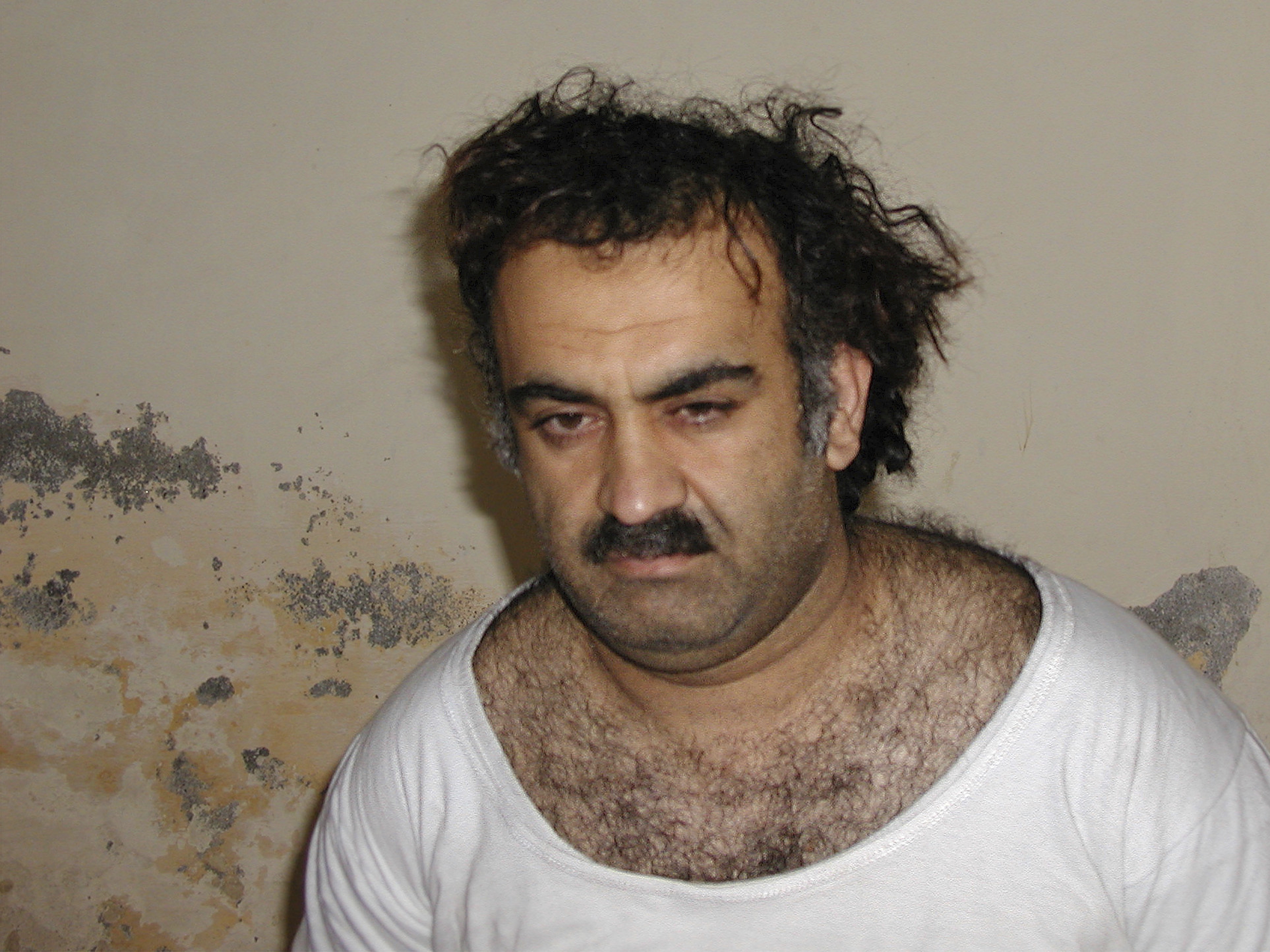 caption: Khalid Sheikh Mohammed, the alleged 9/11 mastermind, is seen shortly after his capture during a raid in Pakistan in March 2003 in this photo obtained by The Associated Press. The man accused of being the main plotter in al-Qaeda's Sept. 11, 2001 attacks has agreed to plead guilty, The Defense Department said Wednesday.