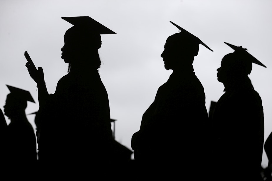 caption: In this May 17, 2018, file photo, new graduates line up before the start of the Bergen Community College commencement at MetLife Stadium in East Rutherford, N.J. Obtaining a college degree has increasingly coincided with ever-higher student debt loads. Since 2004, total student debt has climbed more than 540 percent to $1.4 trillion, according to the New York Federal Reserve. (Seth Wenig, File/AP)
