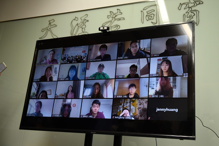 caption: Students are seen on a screen during an online class taken by teacher Fu Zhiyong (top L) at the Academy of Arts and Design at Tsinghua University during a government-organised tour in Beijing on February 28, 2020. (GREG BAKER/AFP via Getty Images)