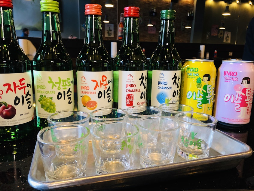 caption: State liquor laws require restaurants to serve distilled spirits like soju by the shot glass. In Korean tradition, it's served by the bottle.  