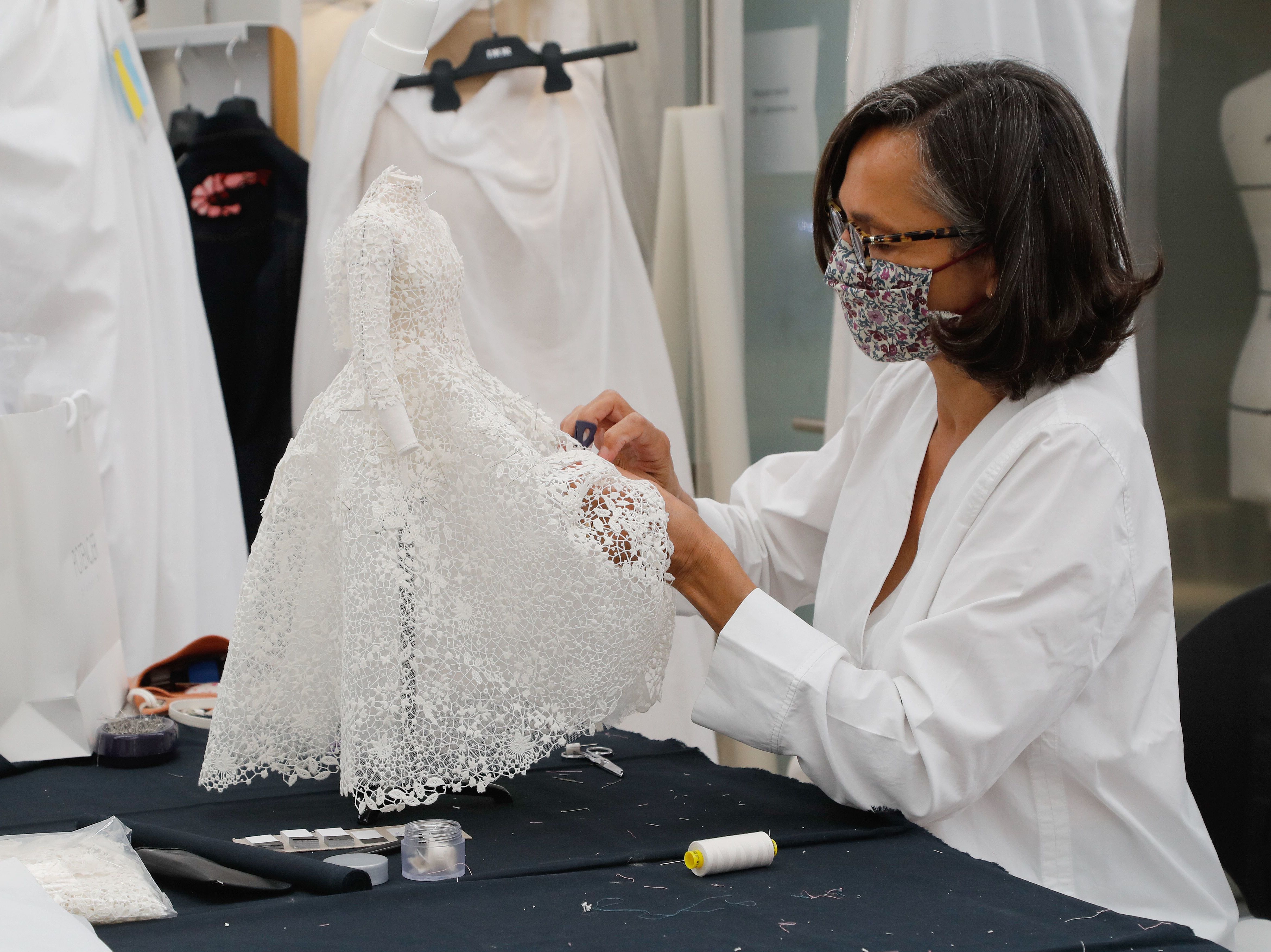 caption: An employee sews a miniature dress in Dior's sewing workshop in Paris on July 4. This year Dior created a miniature collection for its haute couture show and presented it <a href="https://www.youtube.com/watch?v=yxBFwqRbI8c">as a film</a>.