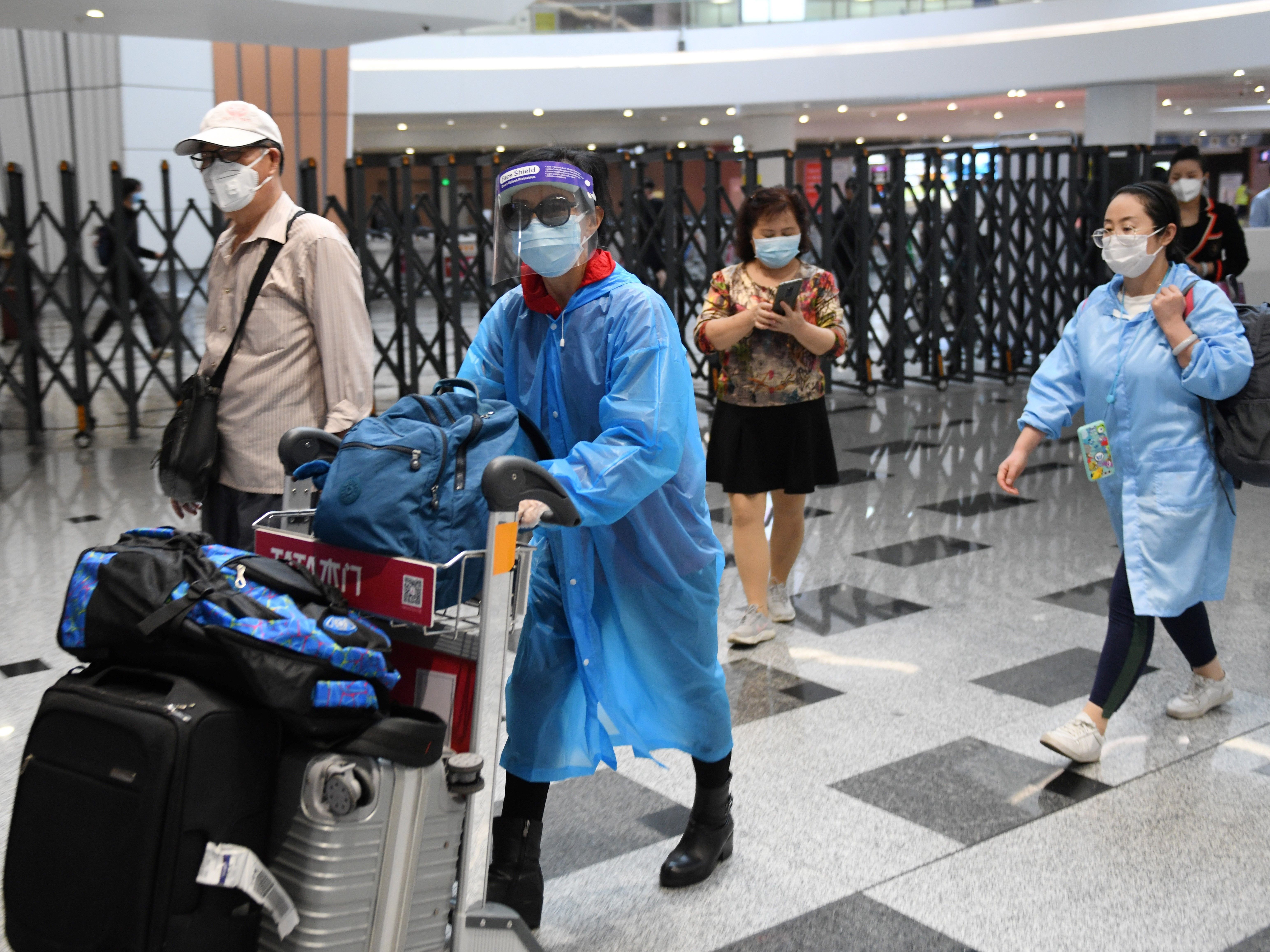 caption: Travelers at Beijing Daxing Airport wear face masks on Thursday to avert the spread of the coronavirus.