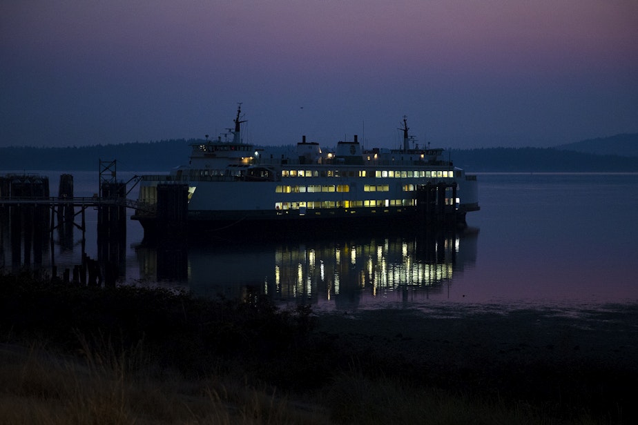 caption: A Washington state ferry is shown docked at the Anacortes ferry terminal as the sun rises on Sunday, Aug. 27, 2023, in Anacortes. 