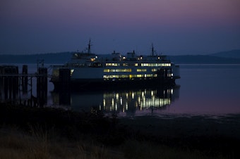 caption: A Washington state ferry is shown docked at the Anacortes ferry terminal as the sun rises on Sunday, Aug. 27, 2023, in Anacortes. 