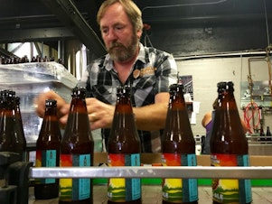 caption: <p>Double Mountain Brewery founder Matt Swihart grabs freshly bottled pale ale from the bottling line in Hood River. The brewery's new beer is among the first to be sold in Oregon's new refillable beer bottles.</p>