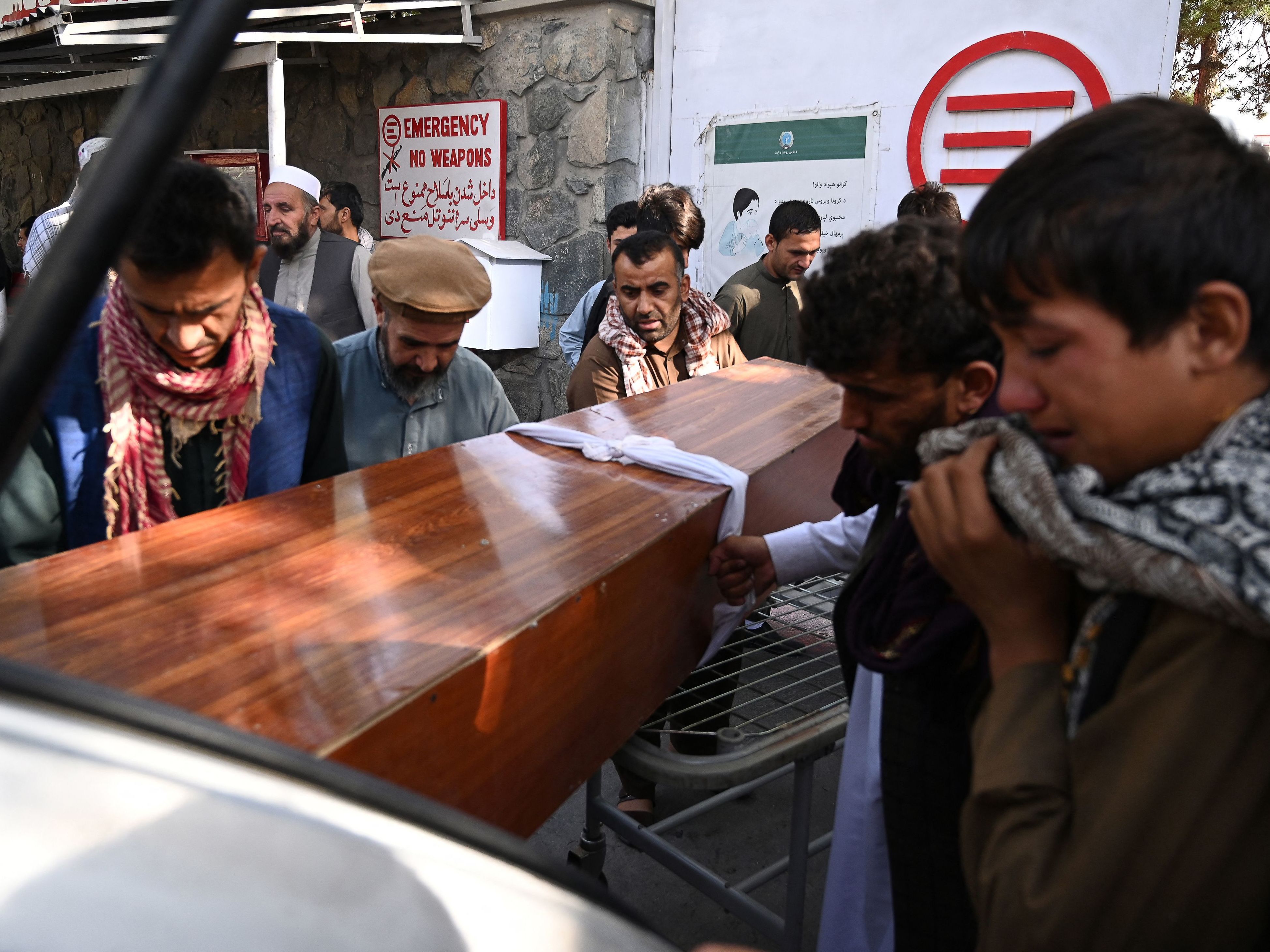 caption: Relatives on Friday load in a car the coffin of a victim of Thursday's explosions, which killed scores of people including 13 U.S. troops outside Kabul's airport, at a hospital run by the Italian NGO Emergency.