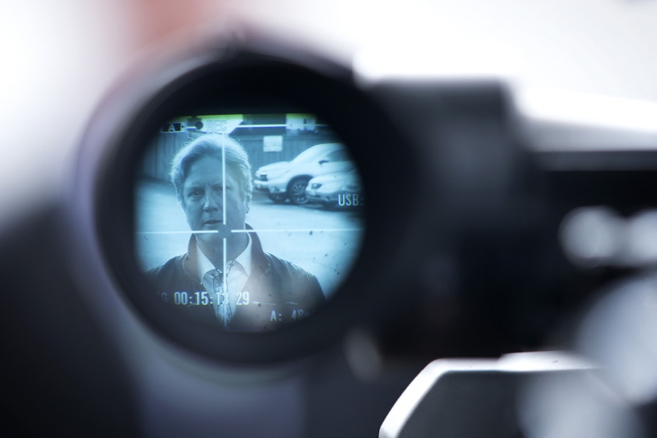 caption: Tim Killian, a public liaison for the Life Care Center of Kirkland, is shown through the viewfinder of a video camera while speaking to the press outside of the long-term care facility on Sunday, March 8, 2020, in Kirkland.