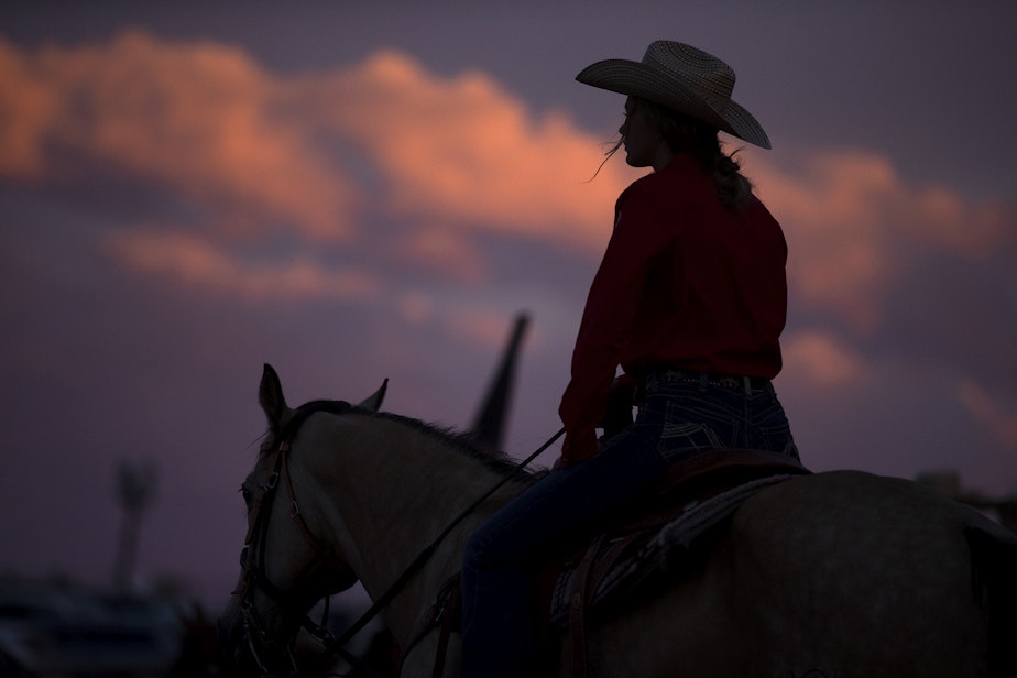 caption: The sun sets on Friday, June 17, 2022, at the Freedom Rodeo in Basin City. 