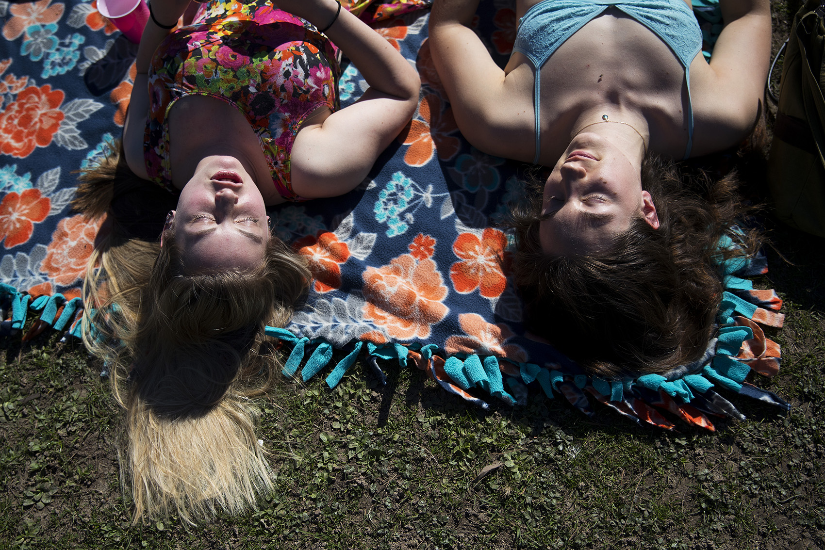 caption: Hanna Peterson, left, and Sophia Cassam lay in the sun on Tuesday, March 19, 2019, at Green Lake in Seattle.