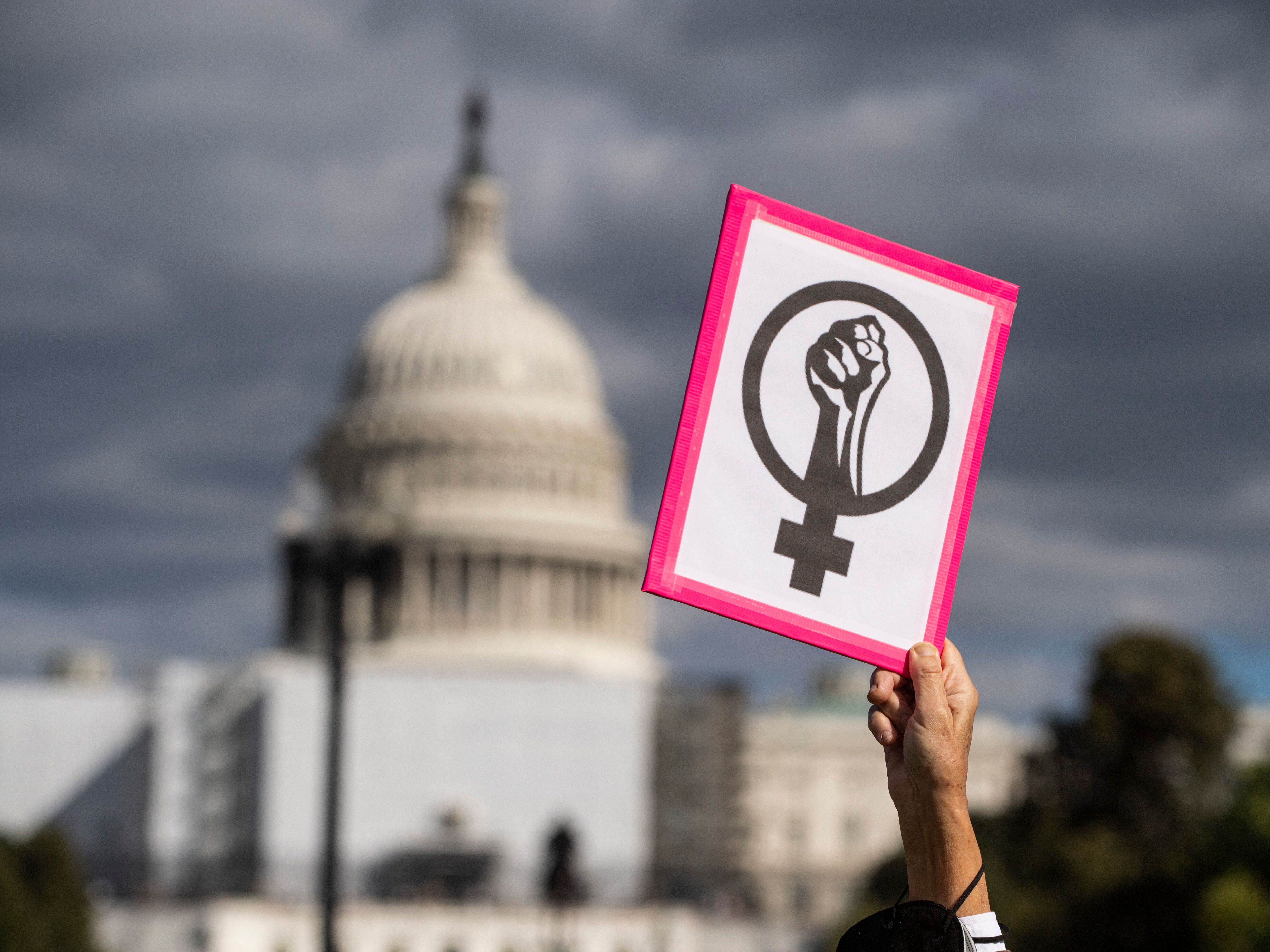 caption: An abortion rights demonstrator holds a sign near the U.S. Capitol during the annual Women's March to support Women's Rights in Washington, D.C., on Oct. 8, 2022.