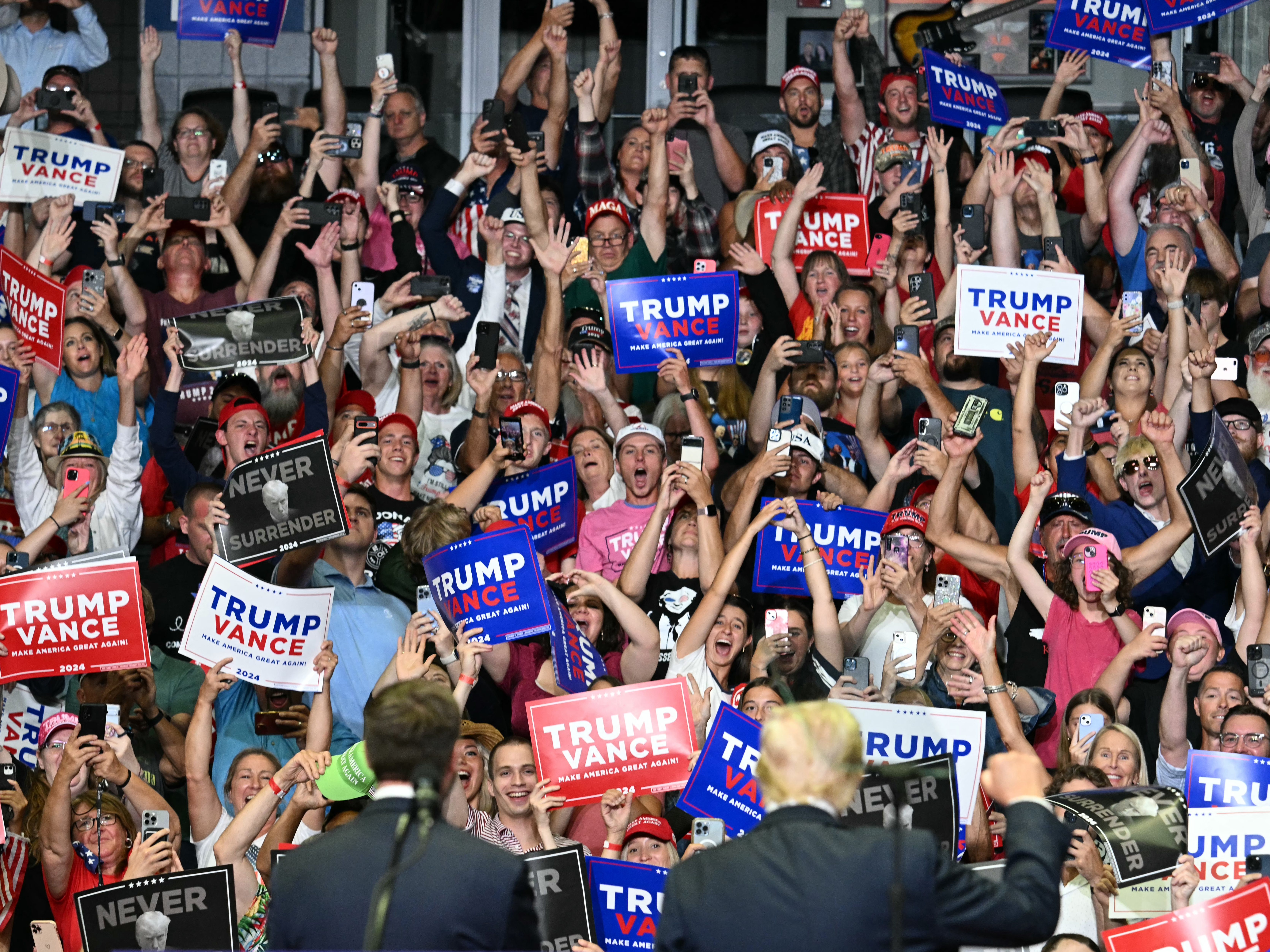 caption: The crowd cheers as former president Donald Trump, right bottom, and Sen. JD Vance attend their first campaign rally together in Grand Rapids, Mich., on July 20.