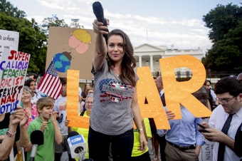 caption: Alyssa Milano says that celebrity activism is at its best "when we are able to hand over the microphone" to the "incredible heroes" doing activism work day to day. She's pictured above in July 2018 at a protest following President Trump's meetings with Russia's Vladimir Putin. A longtime activist, Milano says it's impossible to avoid "the vitriol," especially when talking about the Middle East.