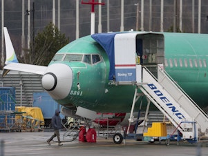 caption: An unpainted Boeing 737 Max 8 is parked at Renton Municipal Airport adjacent to Boeing's factory in Renton, Wash. on January 25, 2024. Boeing is still reeling from the fallout of an Alaska Airlines 737 Max 9 which lost a part of its fuselage in mid-flight earlier in the month.
