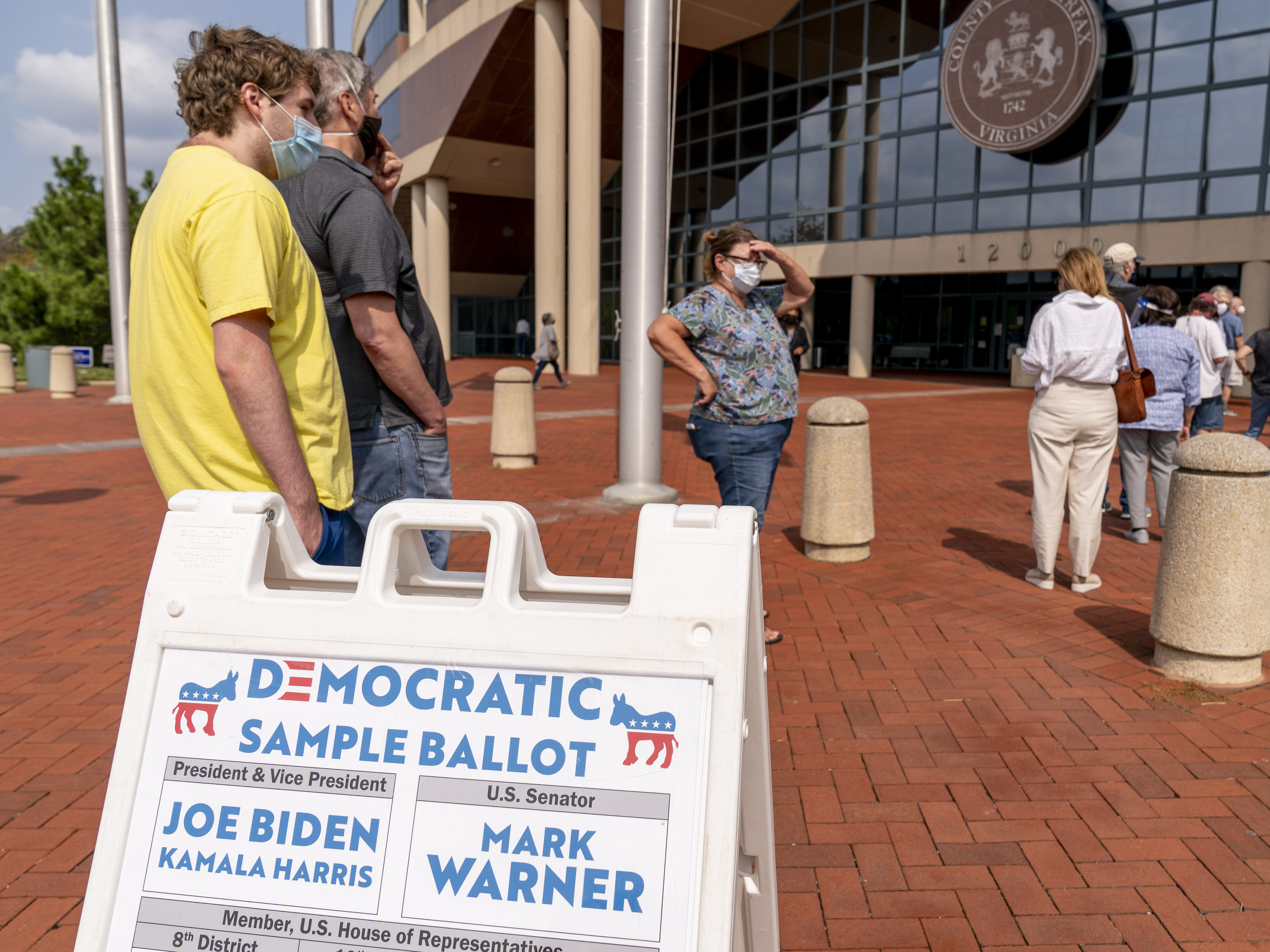 caption: A Democratic sample ballot is on display as hundreds wait in line for early voting at Fairfax County Government Center on Friday in Fairfax, Va.