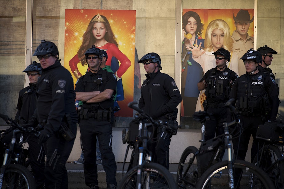 caption: Police officers stand in front of the Spirit Halloween store across the street from the Hyatt Regency where hundreds gathered to protest Secretary of Education Betsy DeVos on Friday, October 13, 2017, in Bellevue.