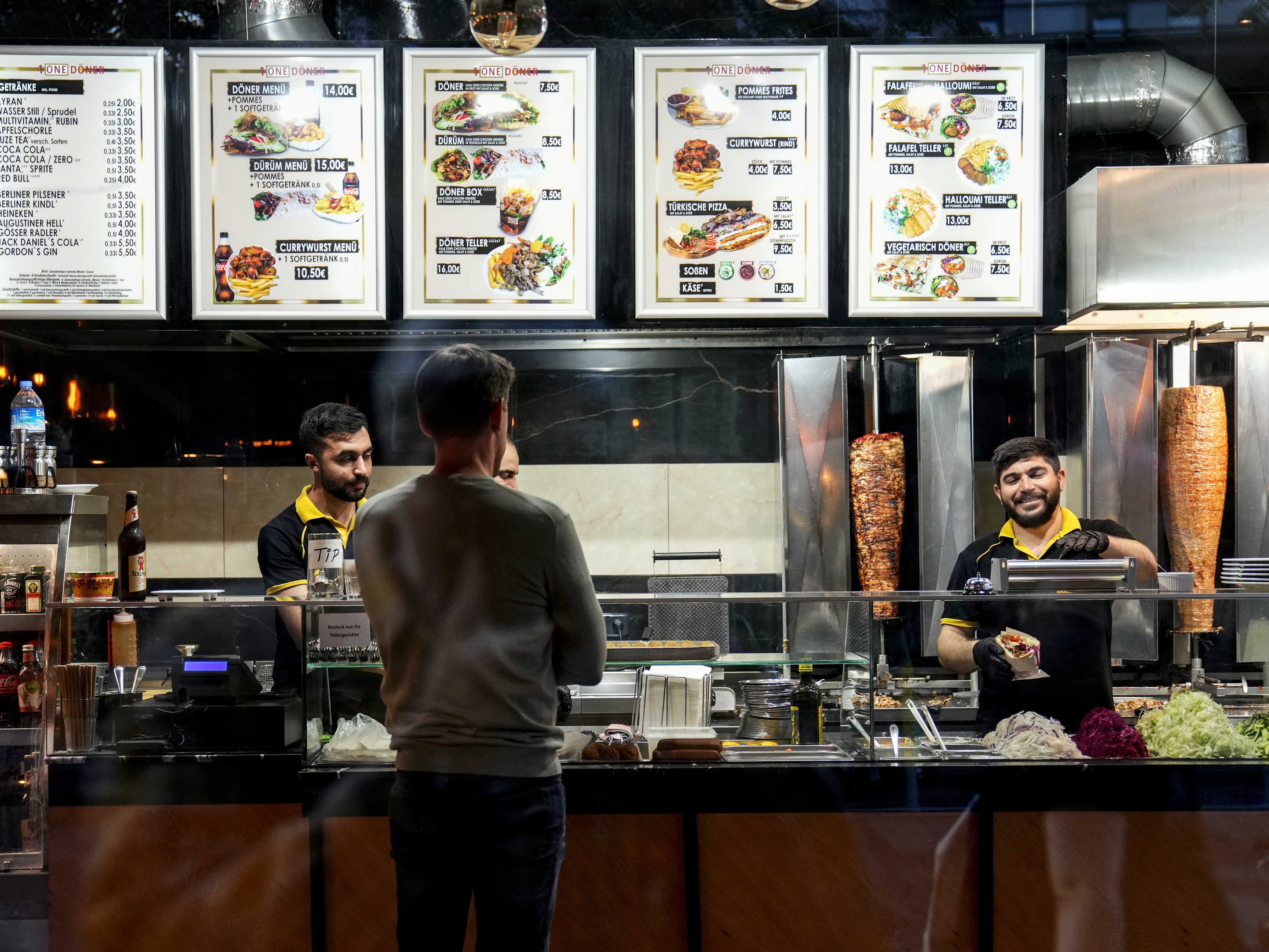 caption: Turkish doner cooks prepare doner kebabs for customers in a doner kebab restaurant in Berlin, Germany, on Wednesday.