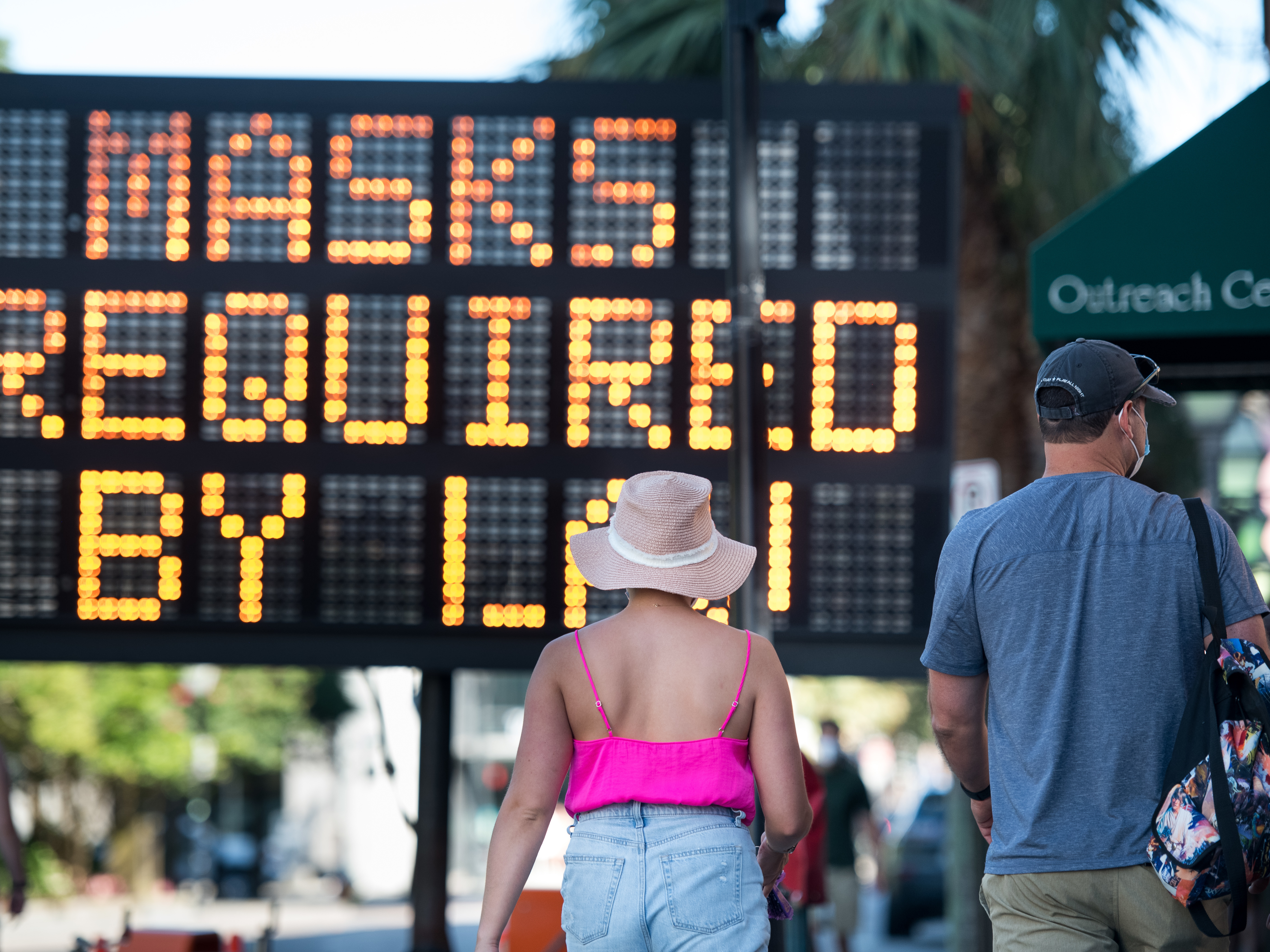 caption: People walk along King St. last week in Charleston, S.C. South Carolina one of many places in the U.S. struggling with a rising number of coronavirus cases.