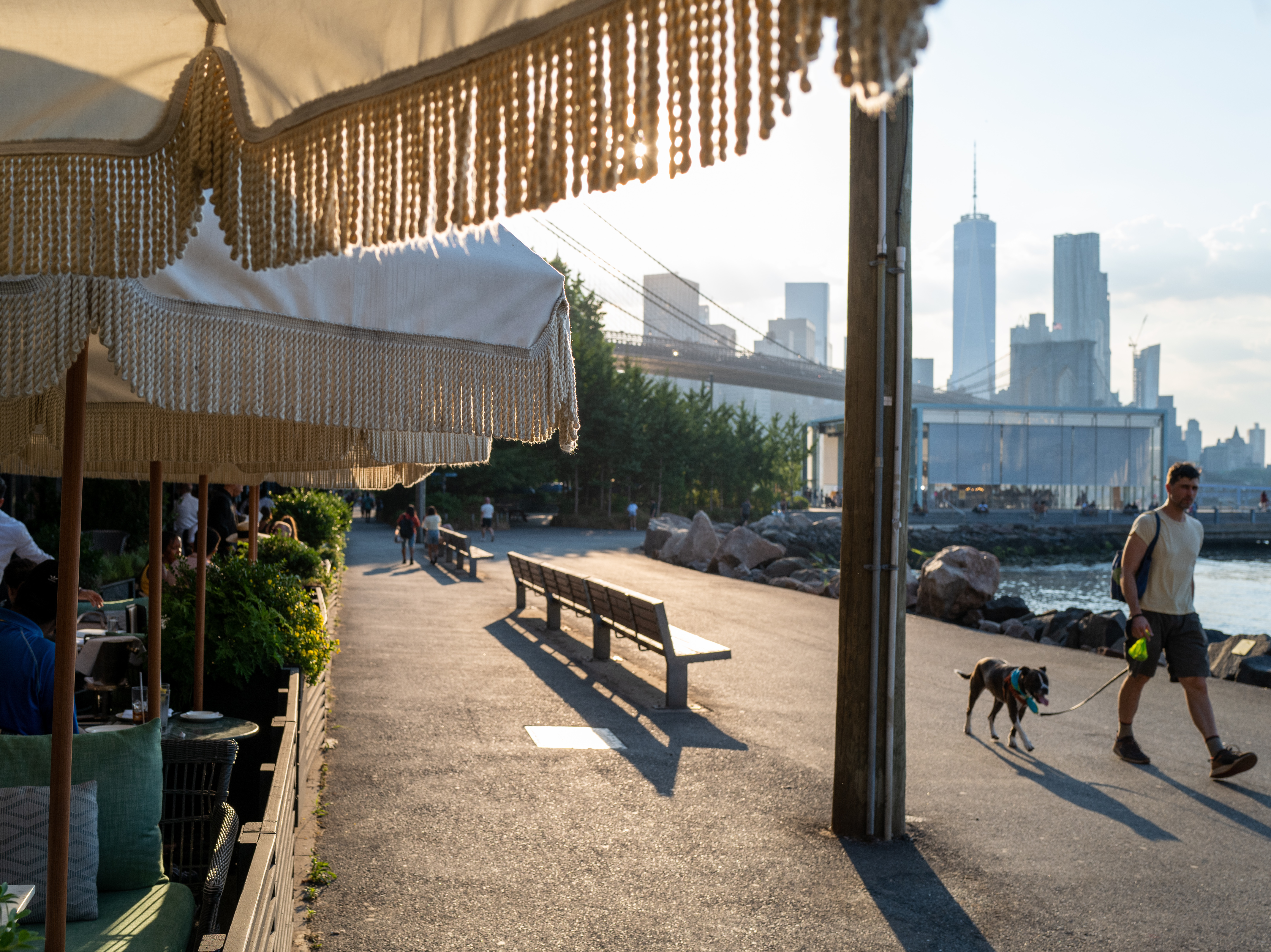 caption: People walk along the East River in Brooklyn, New York, as temperatures reached into the 90s on Wednesday.