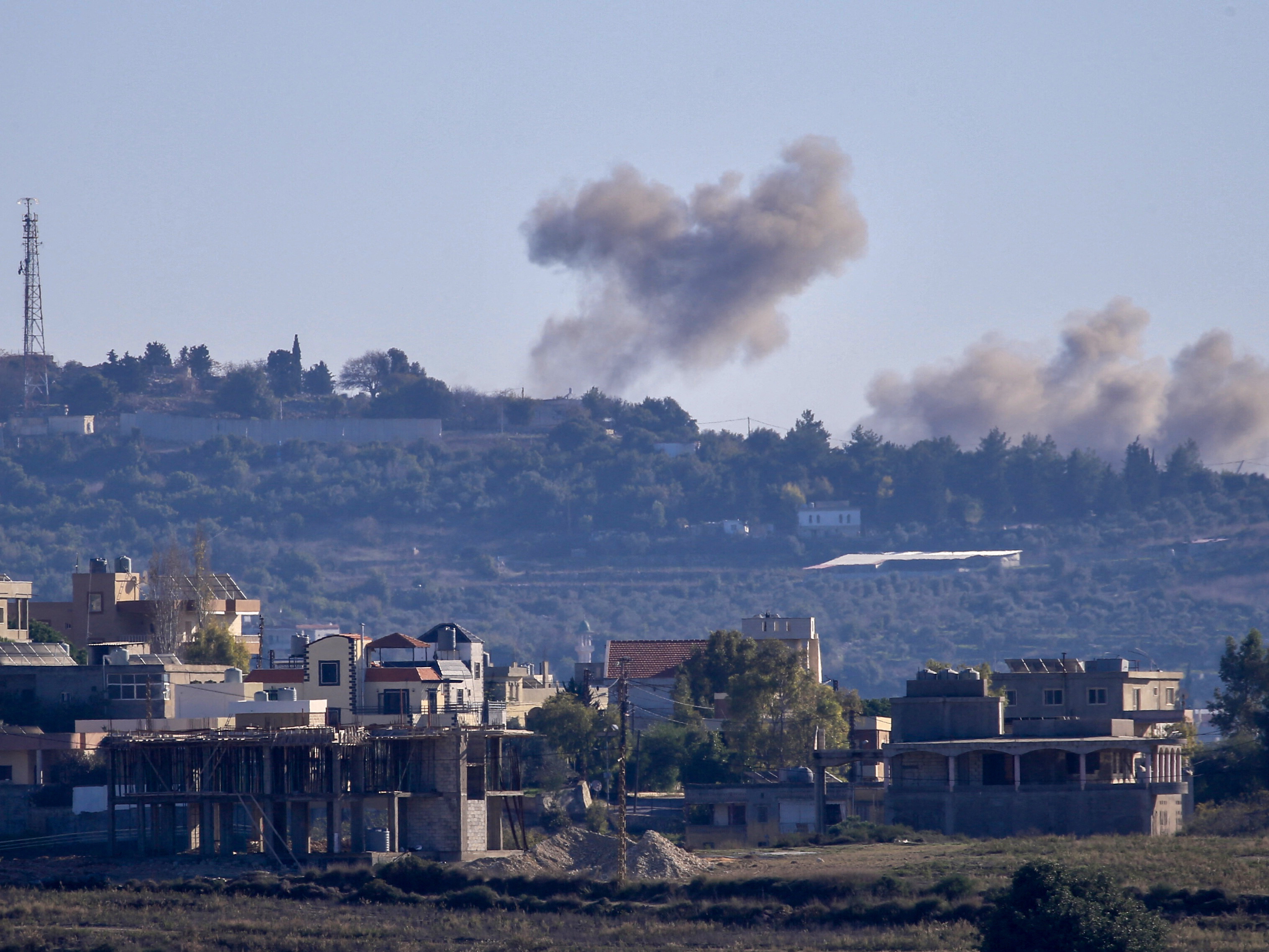 caption: A picture taken from from the southern Lebanese village of Tayr Harfa, near the border with Israel, shows smoke billowing near an Israeli outpost from rockets fired by Hezbollah on Dec. 15.