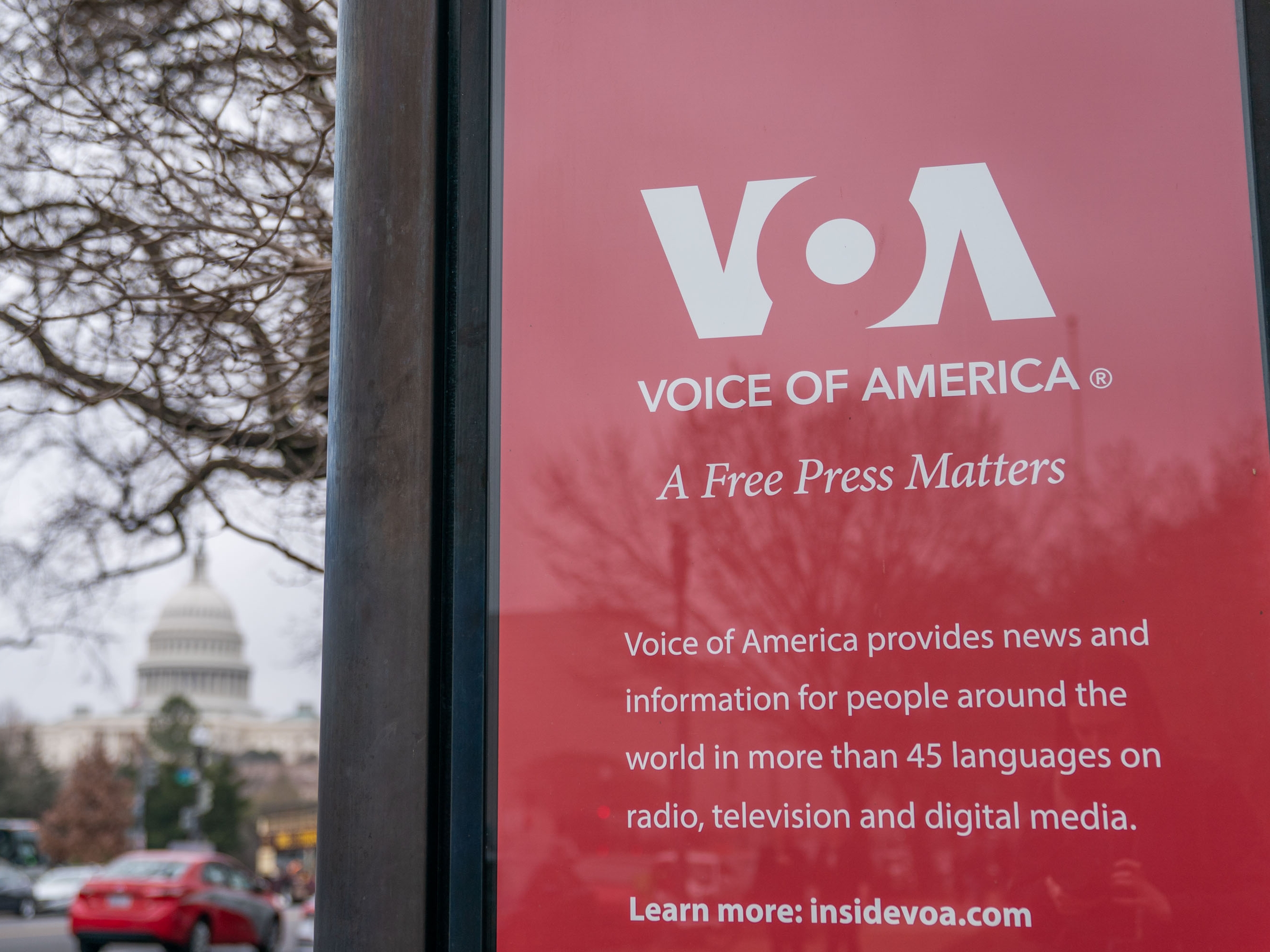 caption: A sign outside of the Voice of America headquarters in Washington, DC, US, in March, shortly after President Trump signed an executive order aimed at reducing the scope of eight federal agencies as part of his campaign to downsize the US government, including the US Agency for Global Media, which oversees Voice of America.