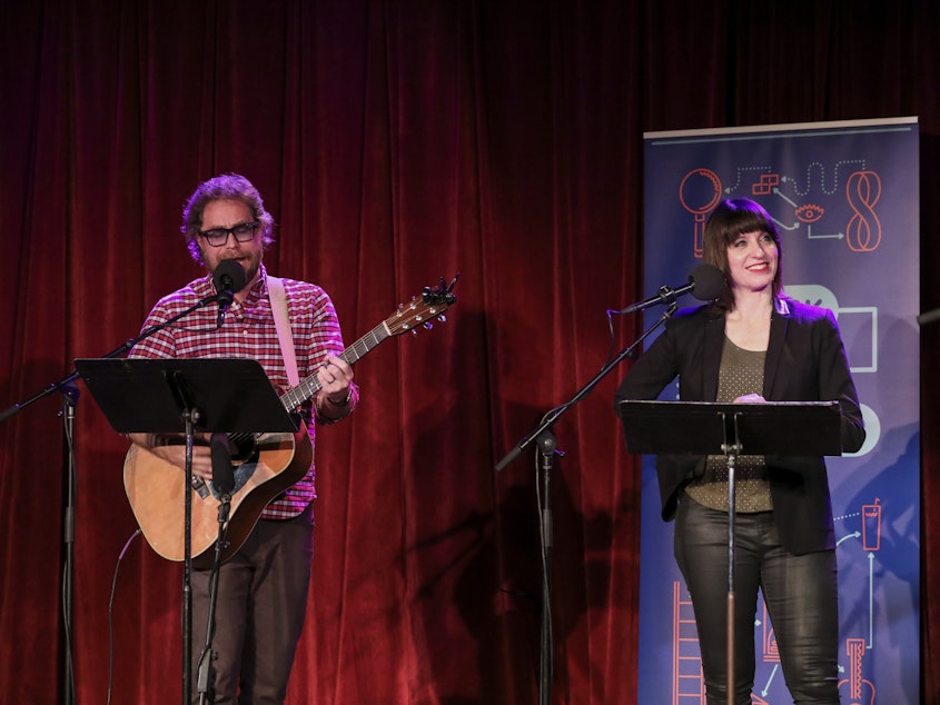 caption: House musician Jonathan Coulton leads a music parody game alongside host Ophira Eisenberg on <em>Ask Me Another</em> at the Bell House in Brooklyn, New York.