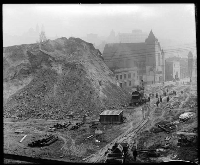 caption: The Denny Hill regrade in progress at 3rd Avenue and Pine, taken 1908 or 1909.