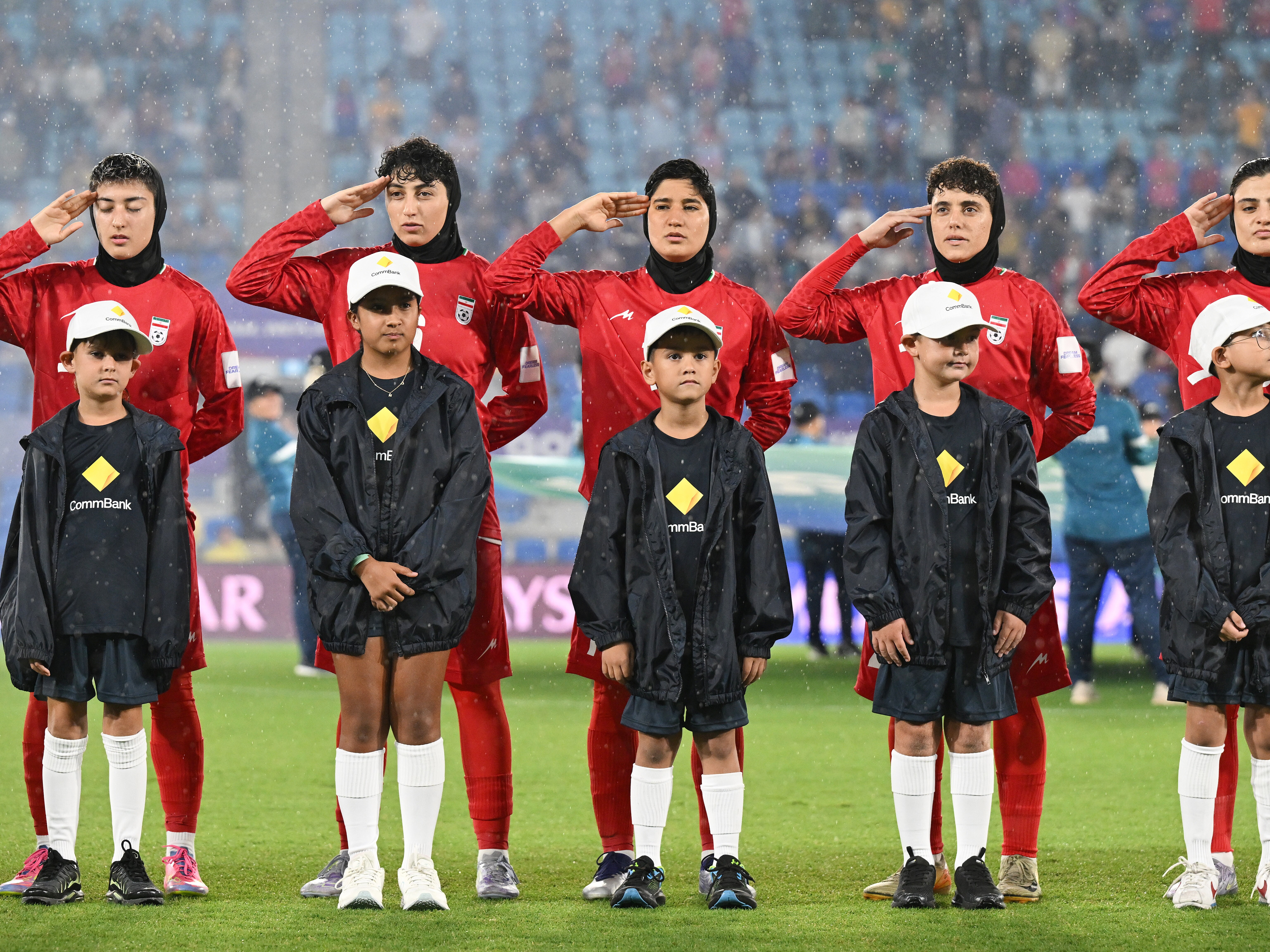 caption: Iran players react during their national anthem ahead of the Women's Asian Cup soccer match between Iran and the Philippines in Robina, Australia, Sunday, March 8, 2026.