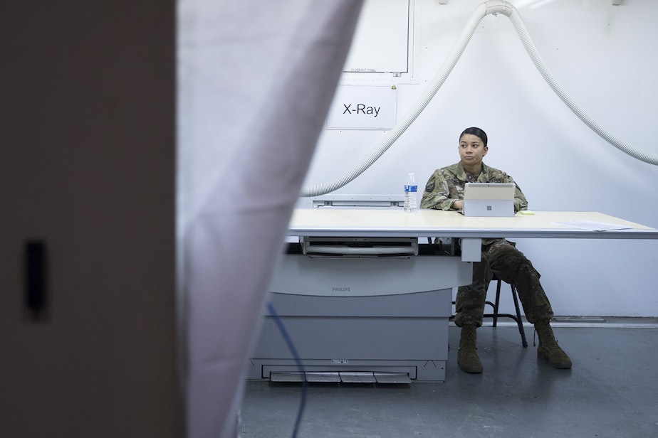 caption: Staff Sgt. Jordan Lambert sits inside the X-Ray area of the military field hospital inside CenturyLink Field Event Center on Sunday, April 5, 2020, in Seattle. The 250-bed hospital for non COVID-19 patients was deployed by U.S. Army soldiers from the 627th Army Hospital from Fort Carson, Colorado, as well as soldiers from Joint Base Lewis-McChord.