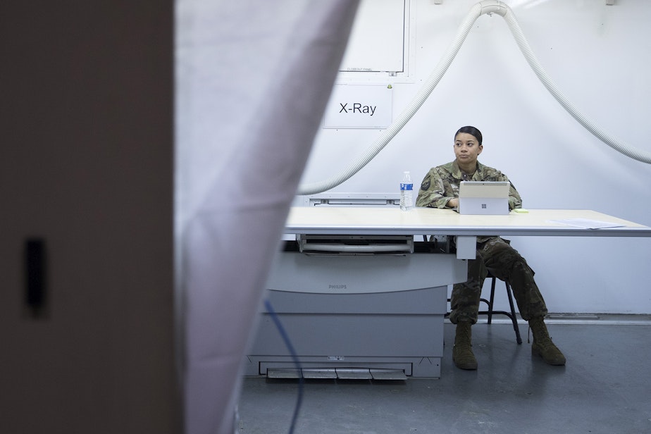 caption: Staff Sgt. Jordan Lambert sits inside the X-Ray area of the military field hospital inside CenturyLink Field Event Center on Sunday, April 5, 2020, in Seattle. The 250-bed hospital for non COVID-19 patients was deployed by U.S. Army soldiers from the 627th Army Hospital from Fort Carson, Colorado, as well as soldiers from Joint Base Lewis-McChord. 