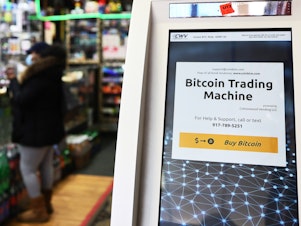 caption: Tesla has pulled back from its $1.5 billion investment in Bitcoin, which it announced in early 2021. Here, a Bitcoin ATM is seen last year inside a New York City store.