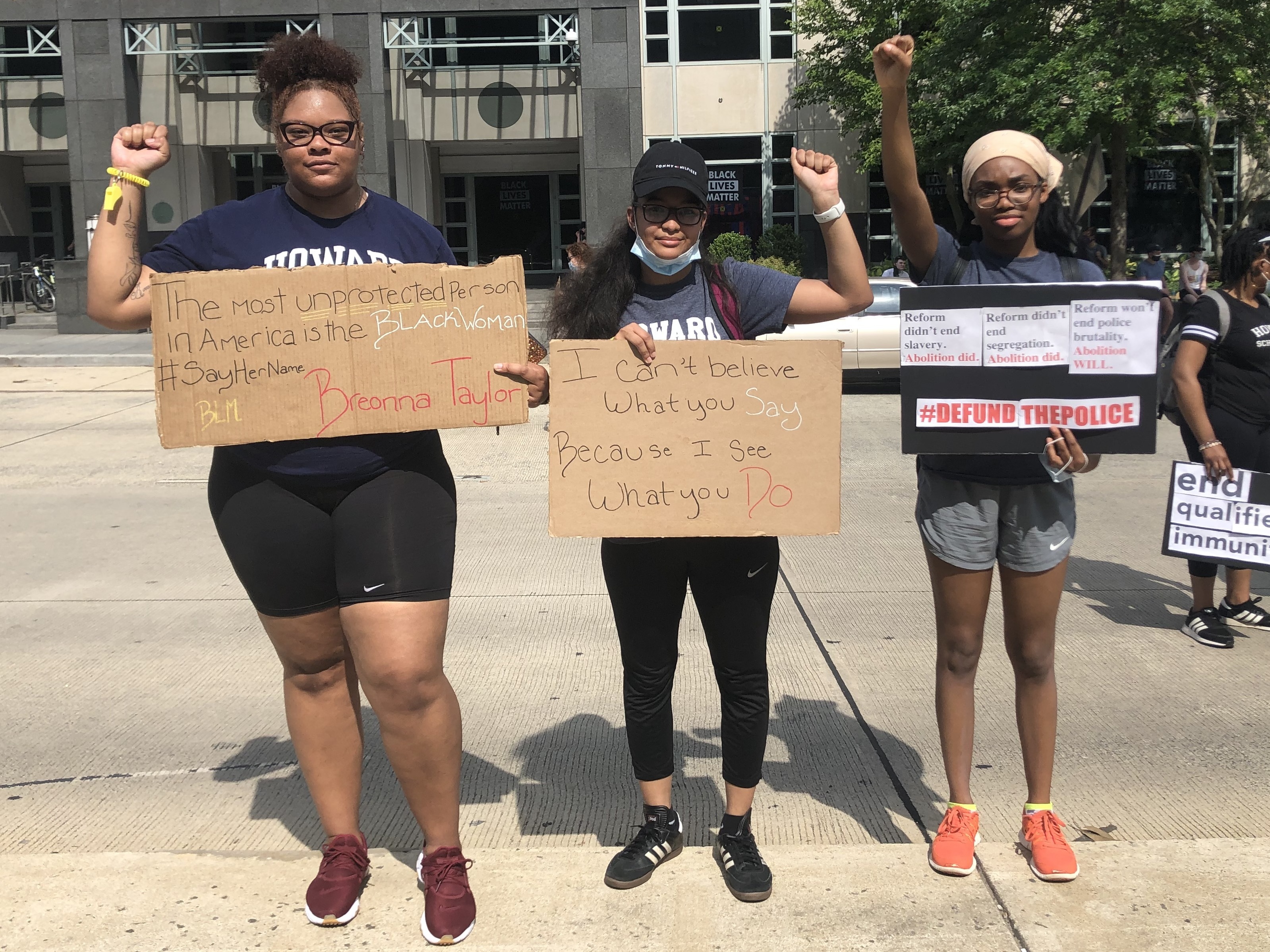 caption: Howard University law students, from left, Chanel Sherrod, Domonique Dille and Temitope Aladetimi brought handmade signs to a protest near the White House last Saturday.