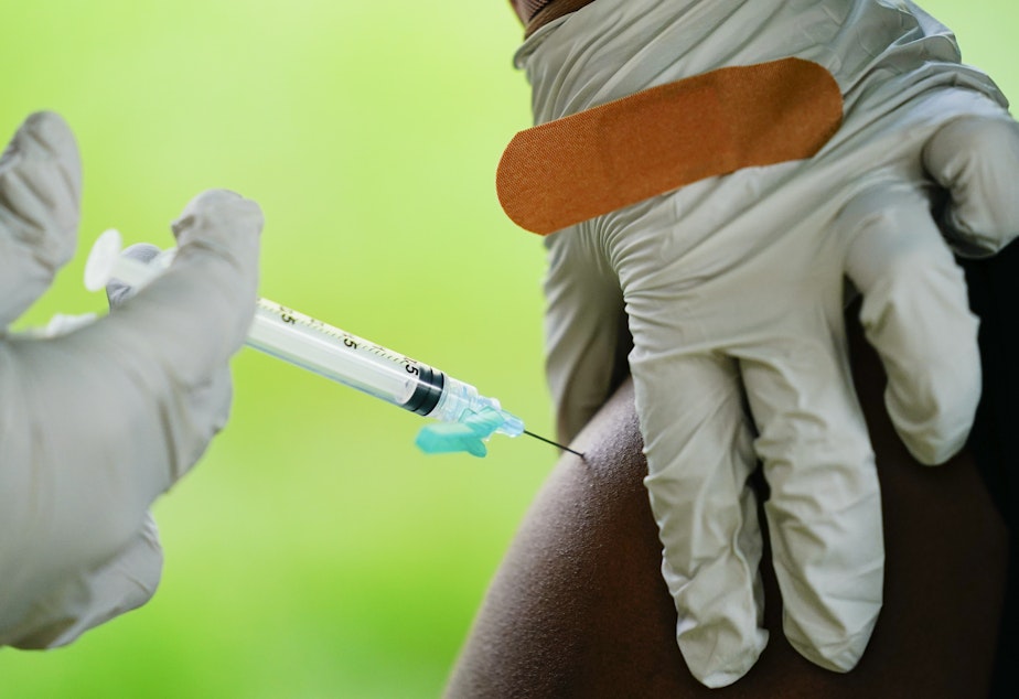 caption: A health worker administers a dose of a Pfizer COVID-19 vaccine during a vaccination clinic earlier this month at the Reading Area Community College in Reading, Pa.