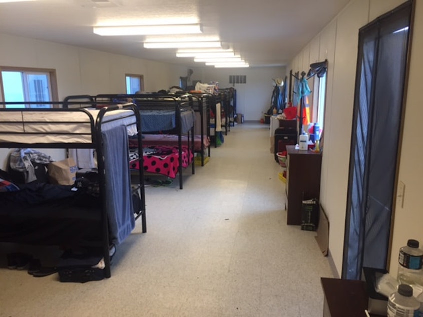 caption: A row of bunk beds in a farmworker housing unit in Sumas, WA.