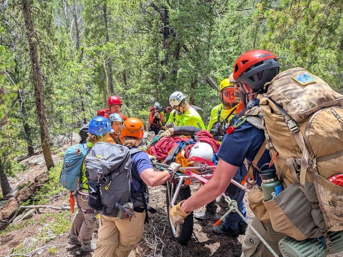 caption: Search and rescue teams used a litter on an all-terrain wheel to bring a stricken hiker to safety. The man had inadvertently been left behind on an office retreat hike.