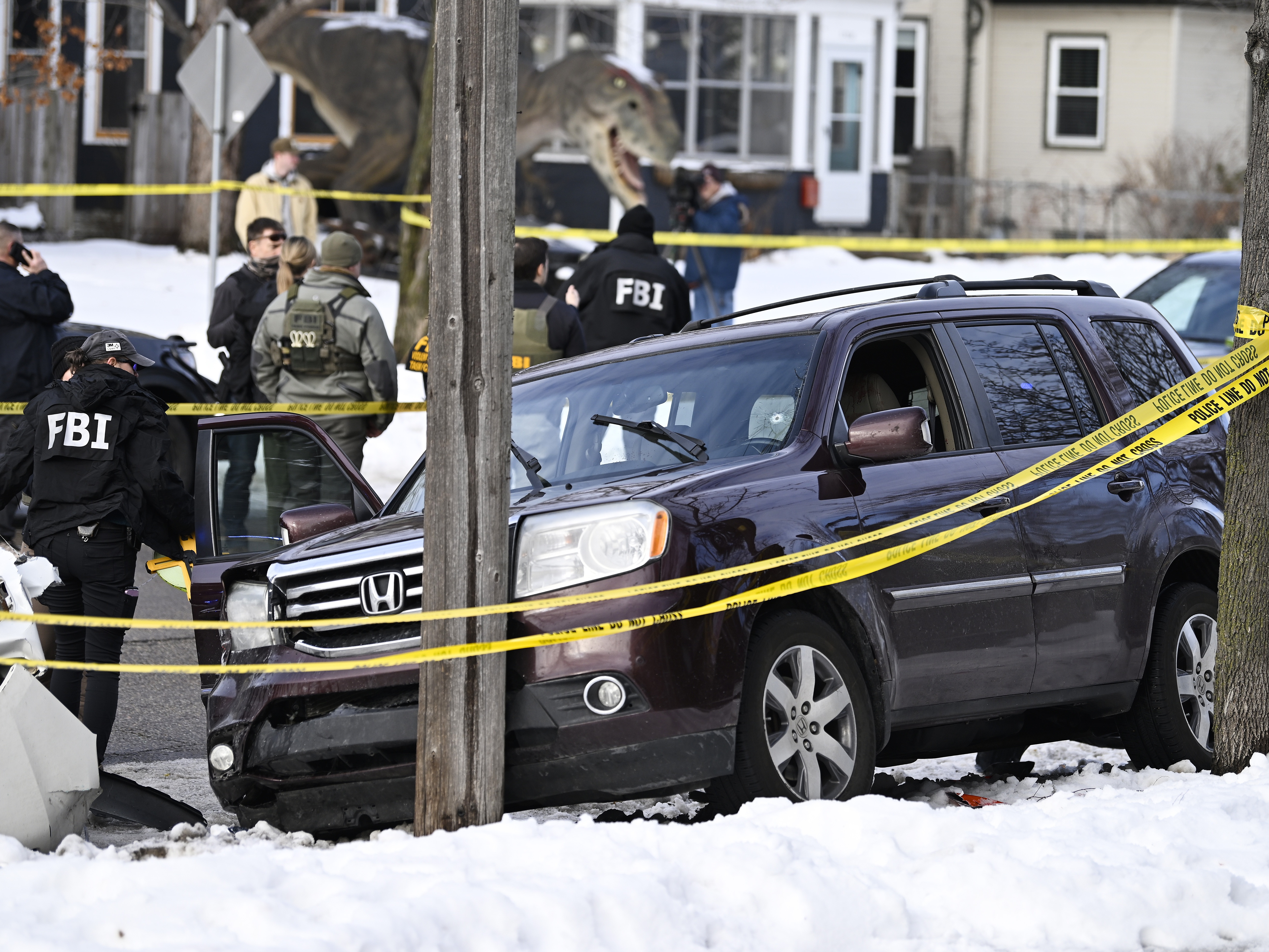 caption: Members of law enforcement work the scene following a shooting by an ICE agent during federal law enforcement operations on Wednesday in Minneapolis.