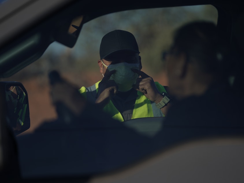 caption: An officer with the Navajo Nation Police talks to a driver at a roadblock in Tuba City, Ariz., on the Navajo reservation on April 22, 2020.