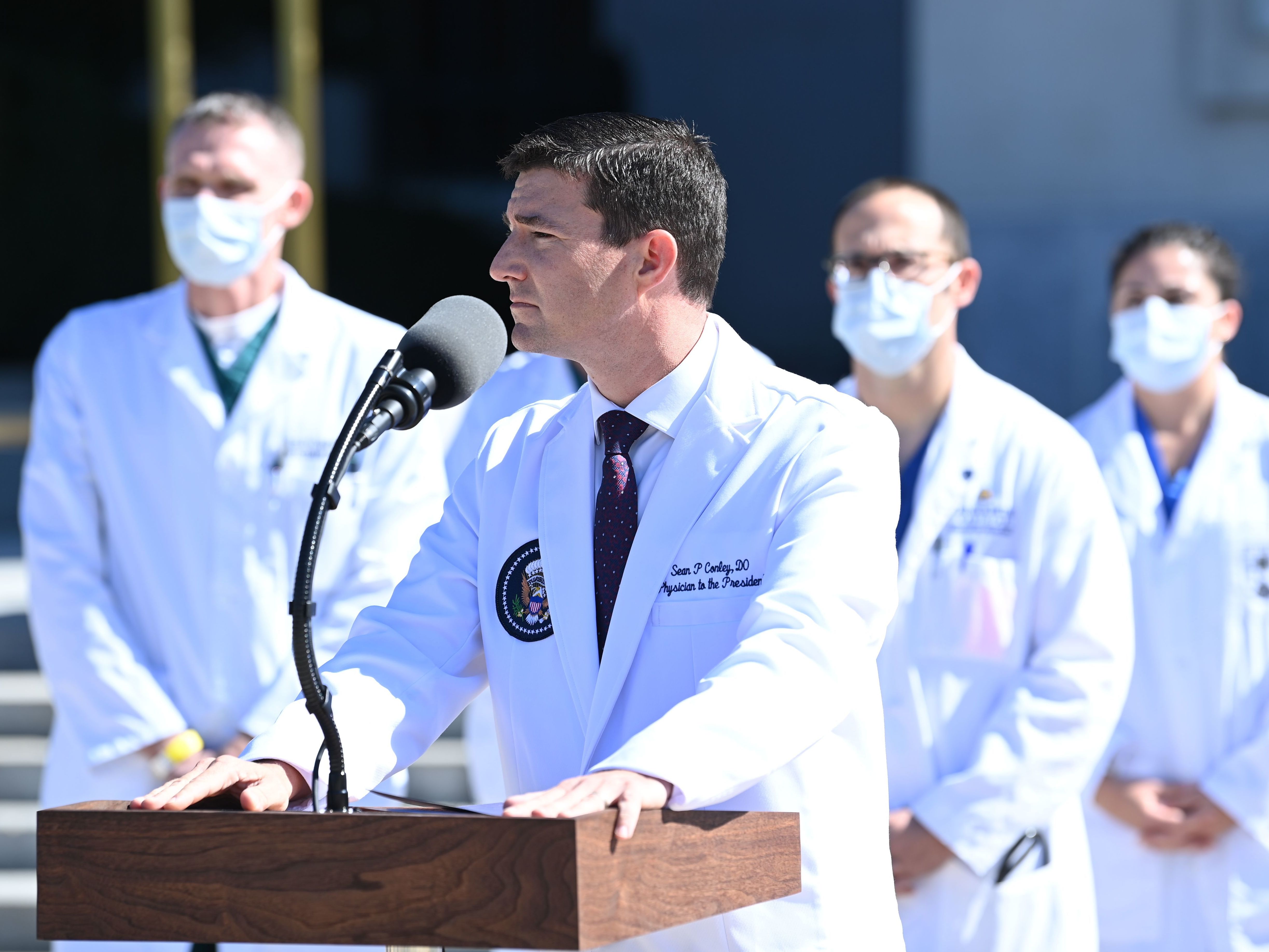 caption: White House physician Sean Conley briefs the press on Saturday on the condition of President Trump, who was hospitalized the evening before because of the coronavirus.
