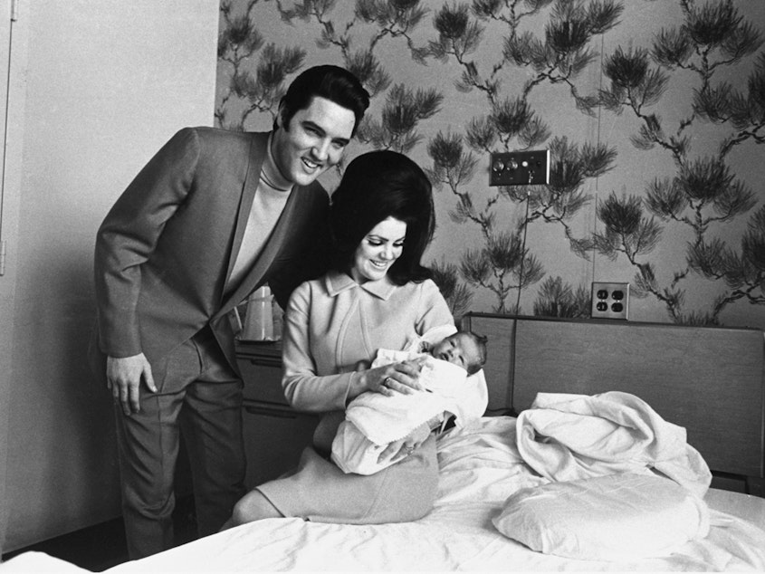 caption: Lisa Marie Presley poses for her first picture in the lap of her mother, Priscilla, on Feb. 5, 1968, with her father, Elvis Presley.