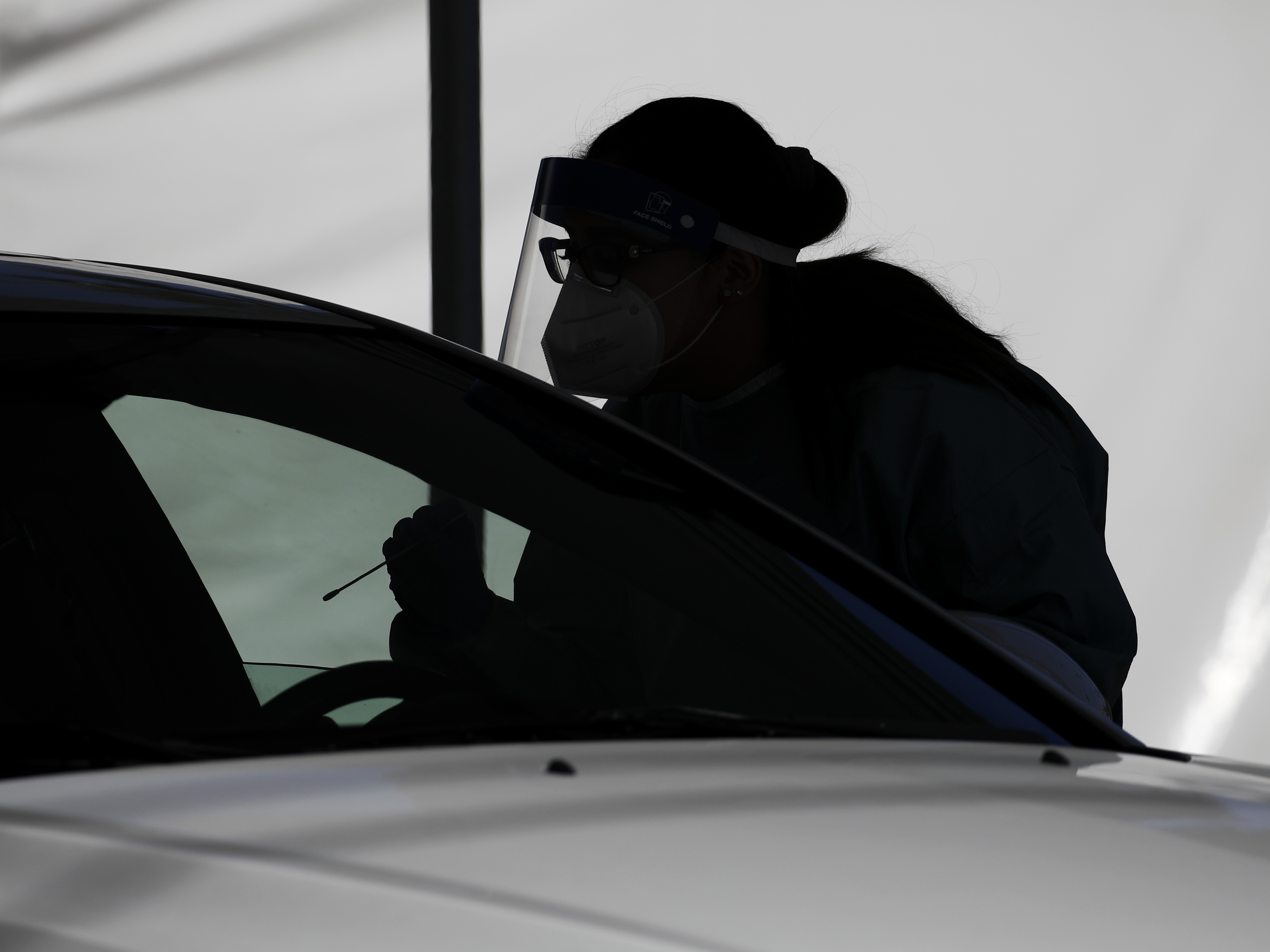 caption: A health care worker tests a patient for the coronavirus in Nevada in July. Scientists say a 25-year-old Nevada man was infected with the virus twice. It is the first confirmed case of reinfection in the U.S.