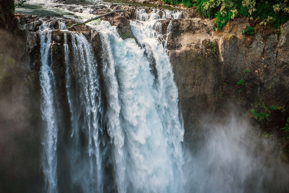 caption: Snoqualmie Falls can be seen with mist rising after hitting the plunge pool below. The falls are 268 feet, and are a popular scenic tourist attraction.