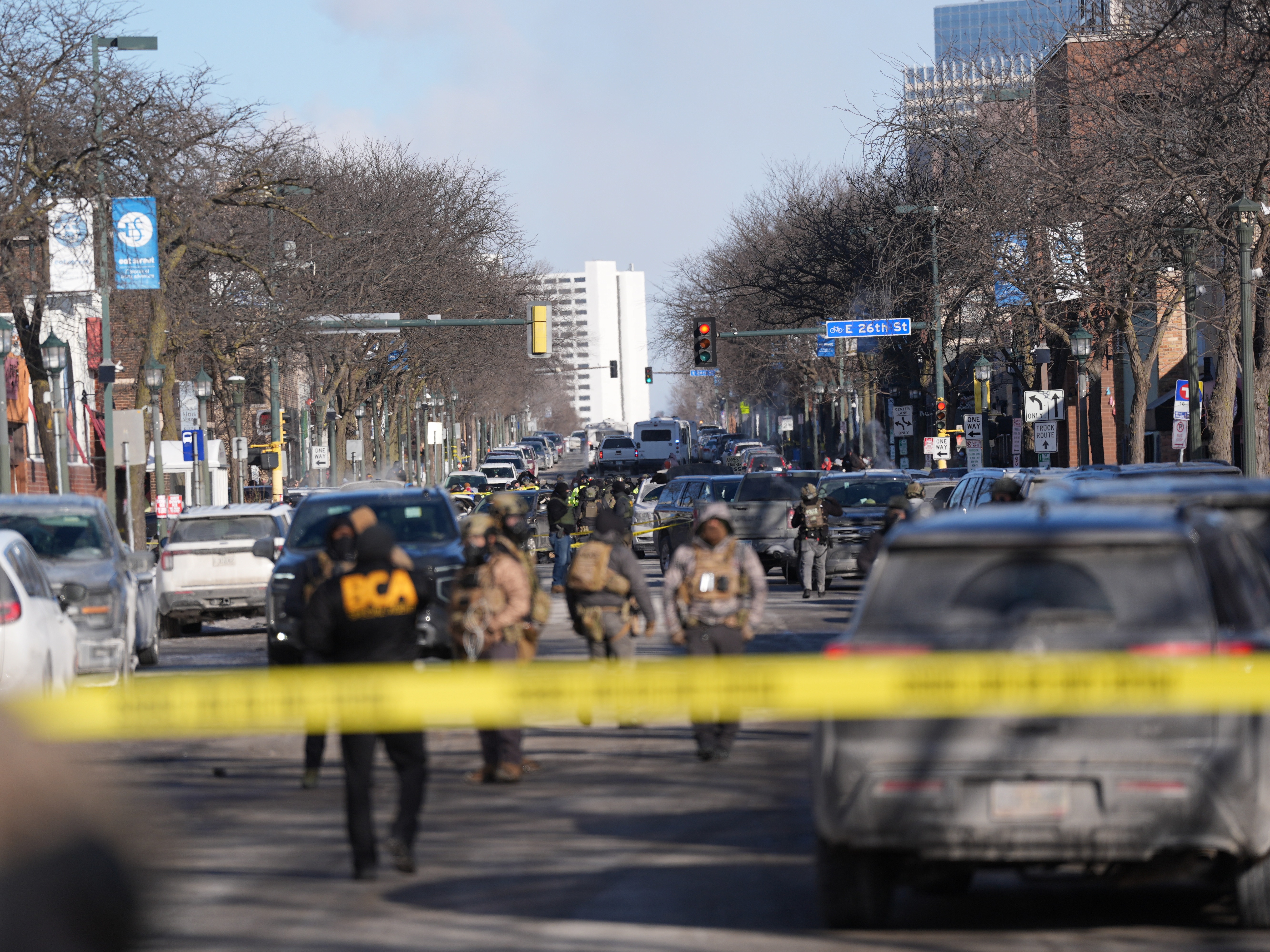 caption: Federal agents stand near the site of a shooting Saturday, Jan. 24, 2026, in Minneapolis.