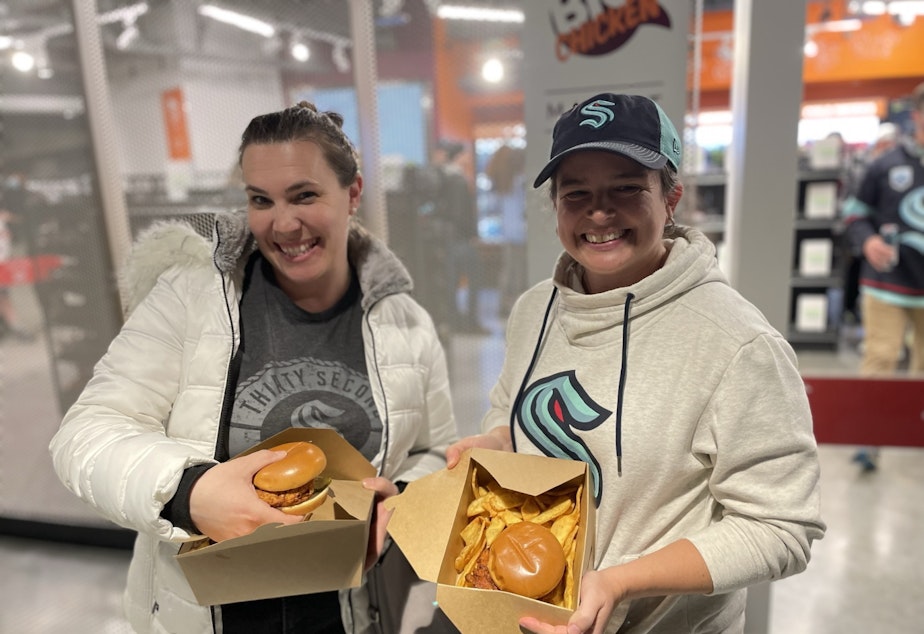 caption: Courtney Fisher (R) and her friend braved the line and got their Kraken Chicken Sandwiches