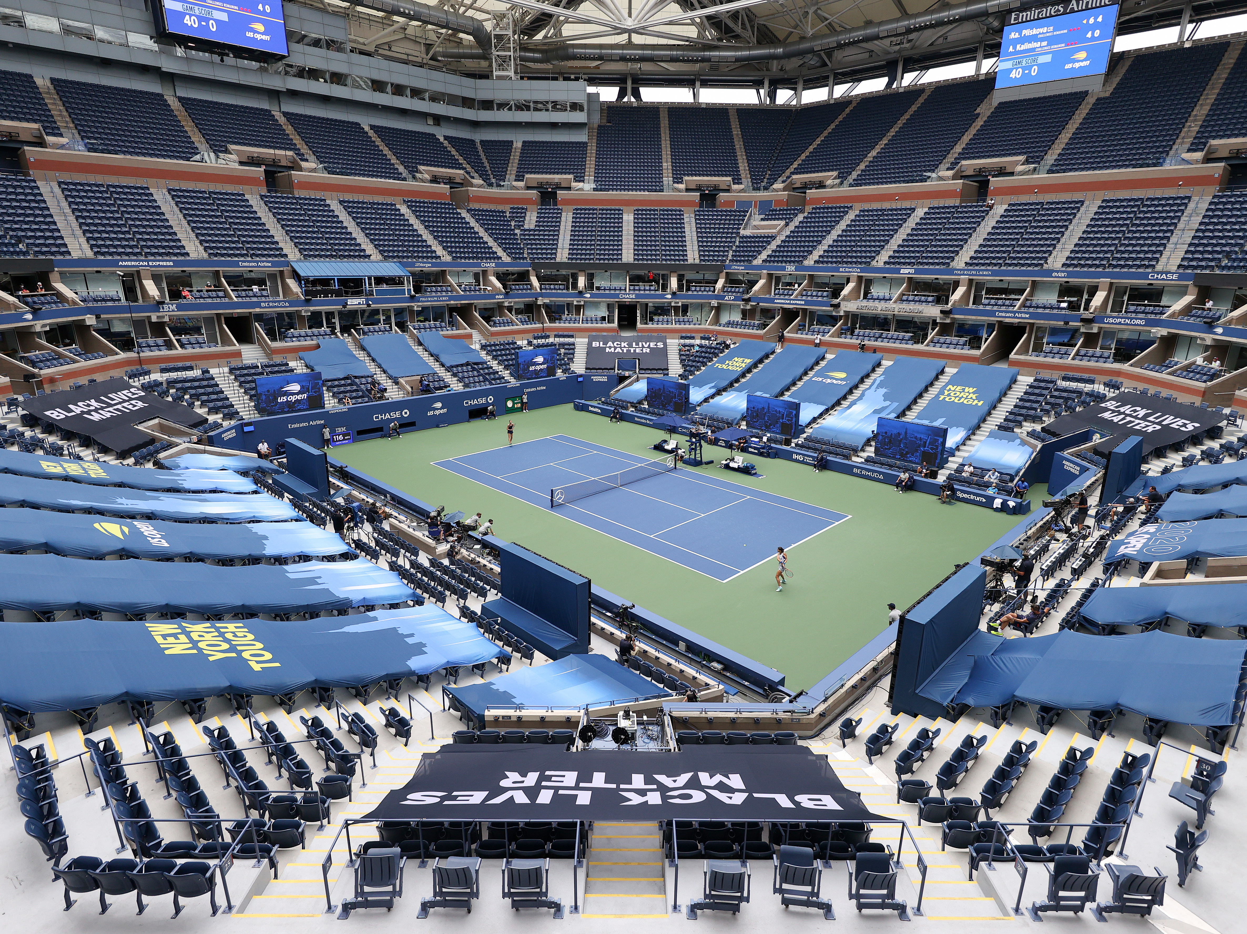 caption: Karolina Pliskova of the Czech Republic and Anhelina Kalinina of Ukraine play their first round match at a mostly empty Arthur Ashe Stadium on Monday. This year's U.S. Open is taking place without spectators because of the coronavirus pandemic.