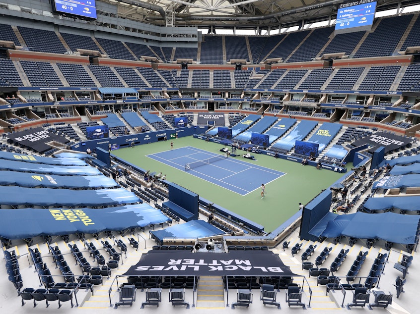 caption: Karolina Pliskova of the Czech Republic and Anhelina Kalinina of Ukraine play their first round match at a mostly empty Arthur Ashe Stadium on Monday. This year's U.S. Open is taking place without spectators because of the coronavirus pandemic.
