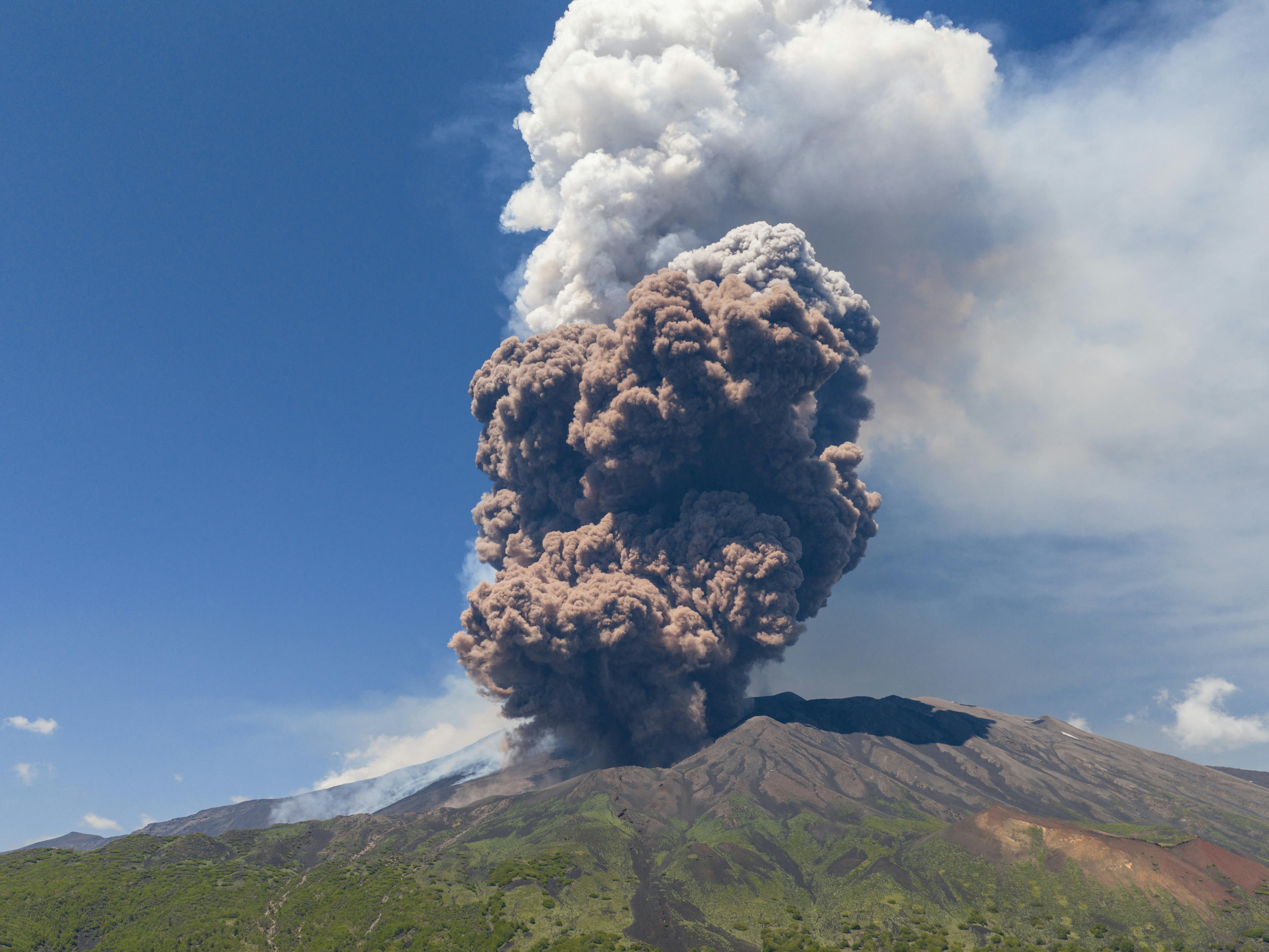 caption: Smoke rises from the crater of the Etna volcano as it erupts, on Mount Etna near Catania, Italy, on Monday. A huge plume of ash, gas and rock spewed forth from Europe's highest active volcano.