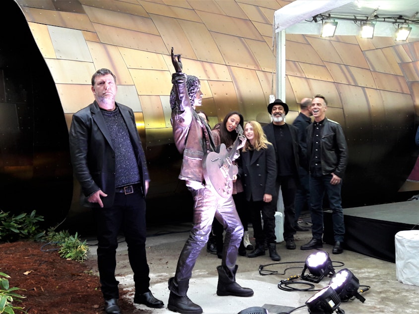 caption: Members of Soundgarden stand next to a life-size statue of their former bandmate, Chris Cornell, outside Seattle's music museum, MoPop. Cornell was found dead in a Detroit hotel room in 2017, hours after a Soundgarden concert.